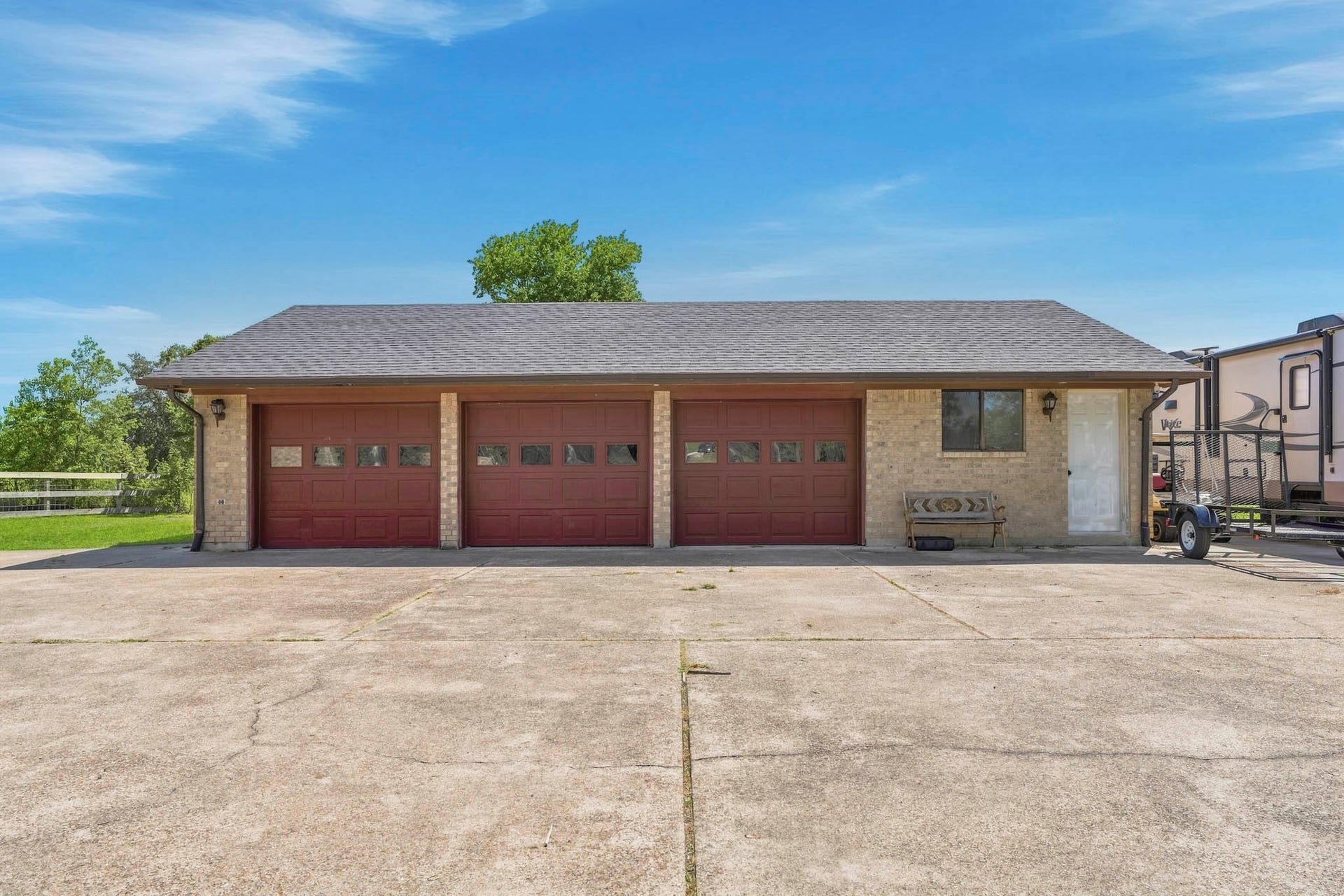 16101 Bluebird Street, Santa Fe, TX 77517 Spacious three-car oversized garage with classic brick exterior, complemented by a wide driveway for ample parking.