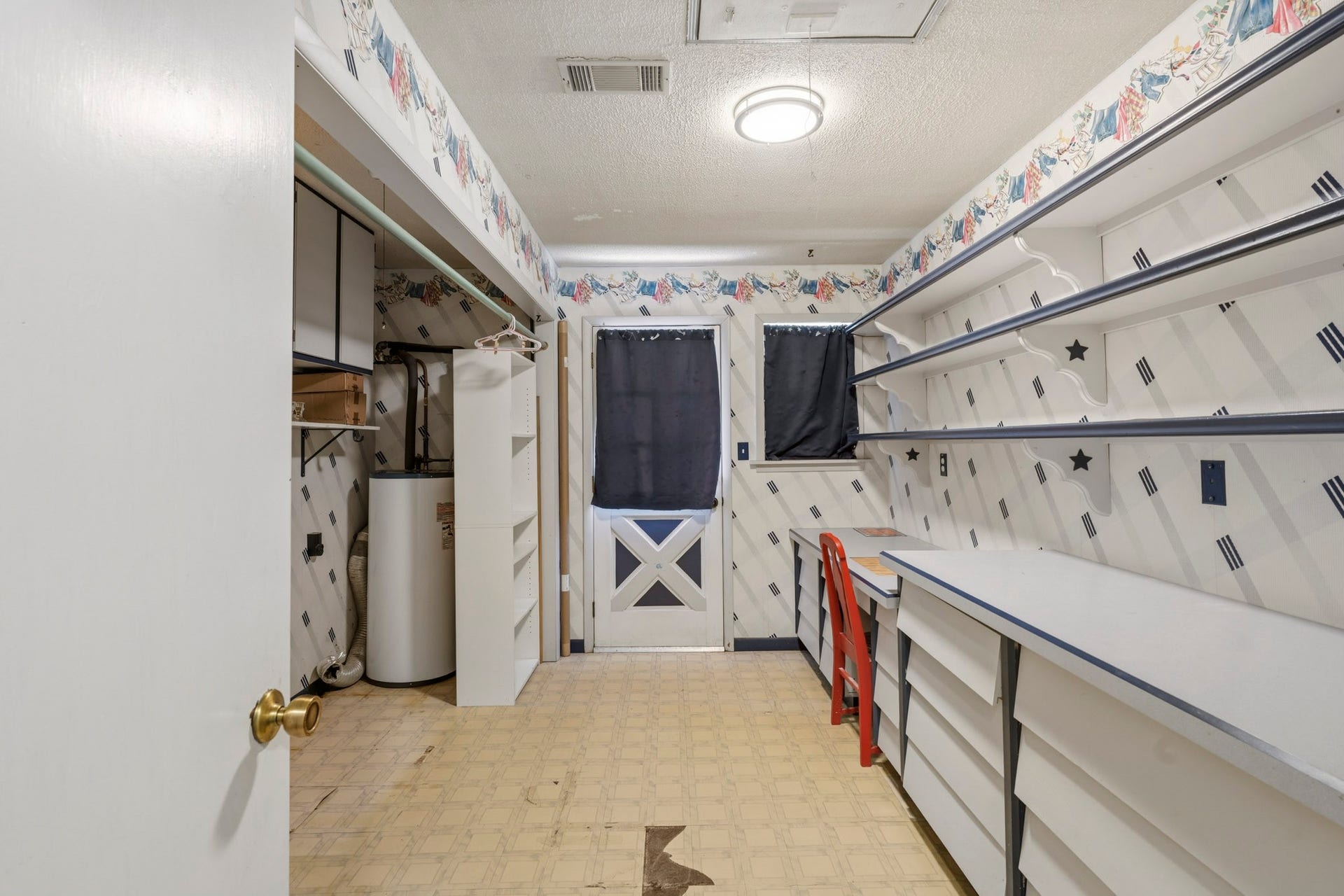 16101 Bluebird Street, Santa Fe, TX 77517 Spacious utility room with ample shelving and storage, featuring a convenient workbench area and classic cabinetry.