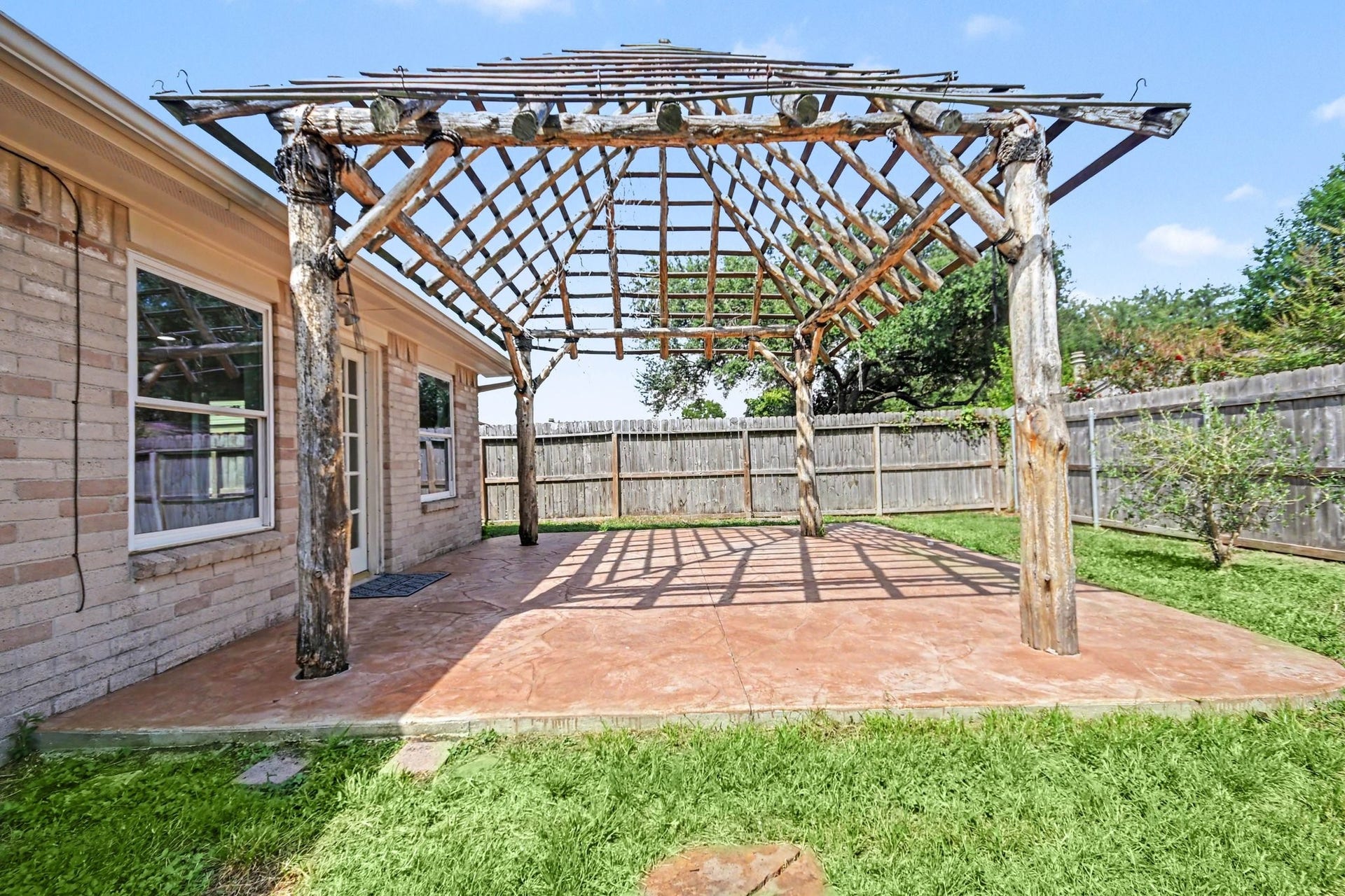 4010 Bluebonnet Trail, Deer Park, TX 77536 Spacious backyard with a well-maintained lawn, featuring a charming pergola perfect for outdoor gatherings and relaxation.