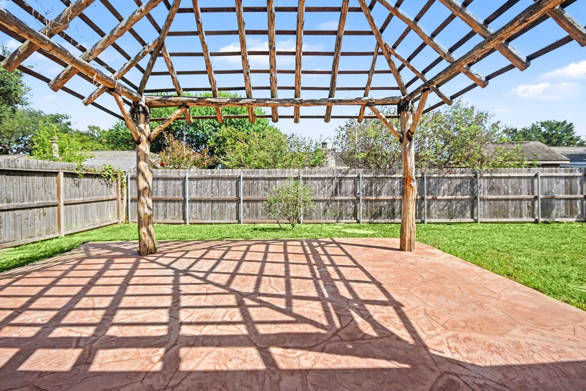 4010 Bluebonnet Trail, Deer Park, TX 77536 Charming backyard with a rustic pergola, perfect for outdoor gatherings and relaxation.