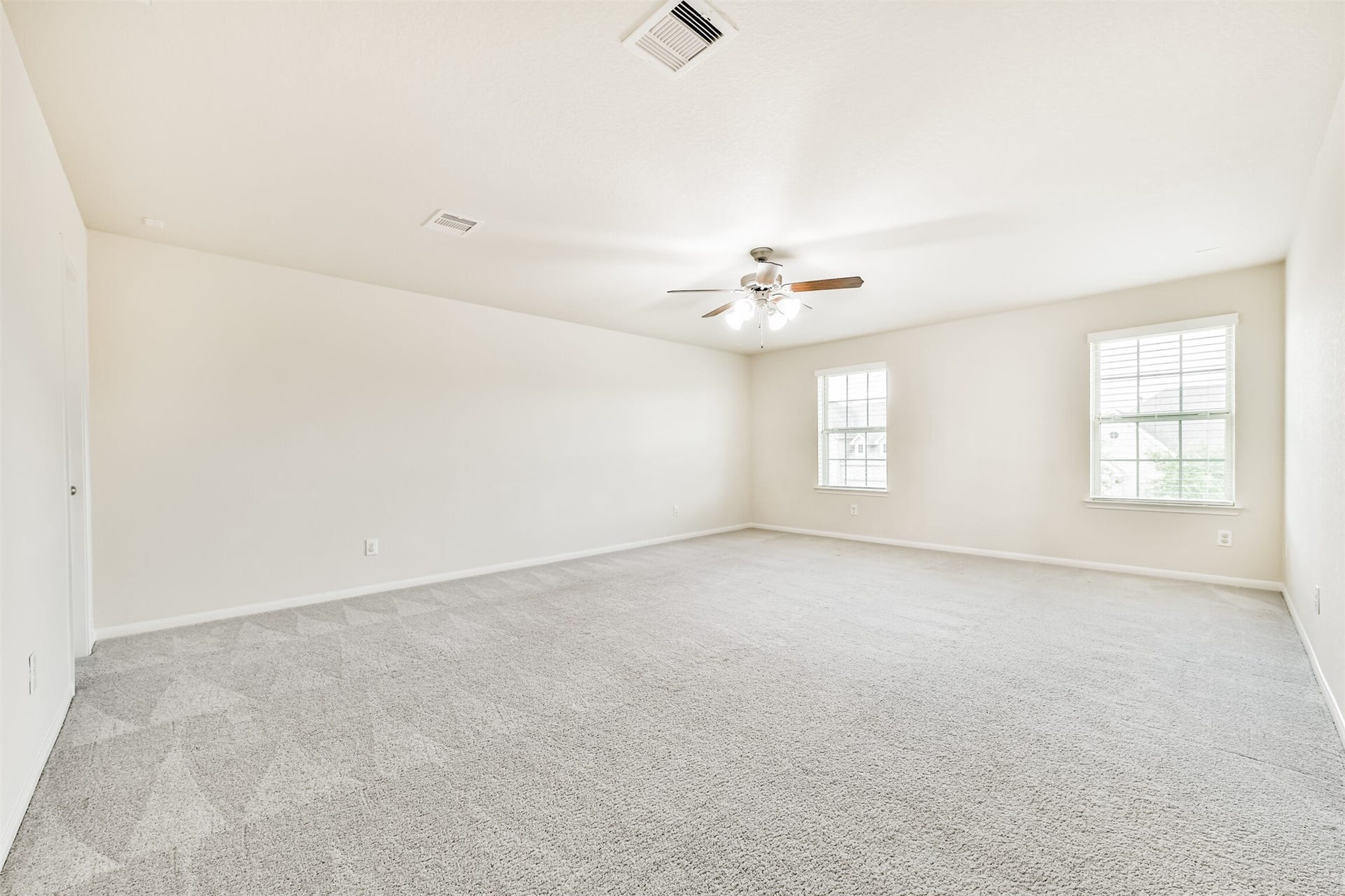 2811 Afton Drive, Pearland, TX 77581 Spacious upstairs game room with abundant natural light and plush carpeting, perfect for entertainment and relaxation.