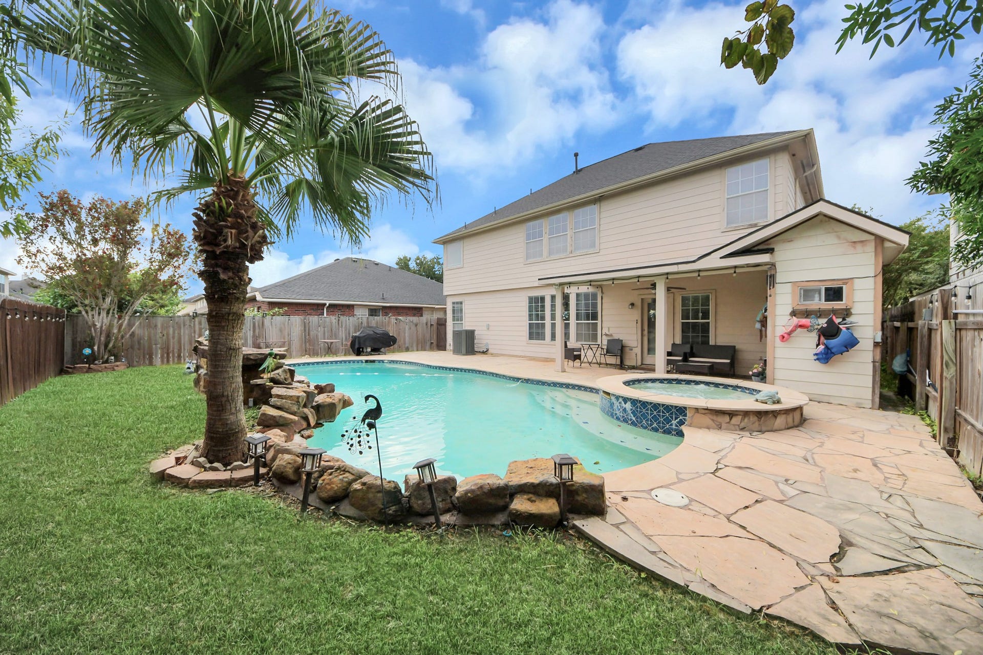 The backyard offers low maintenance green space, a beautiful pool for entertaining, and a convenient half bath
