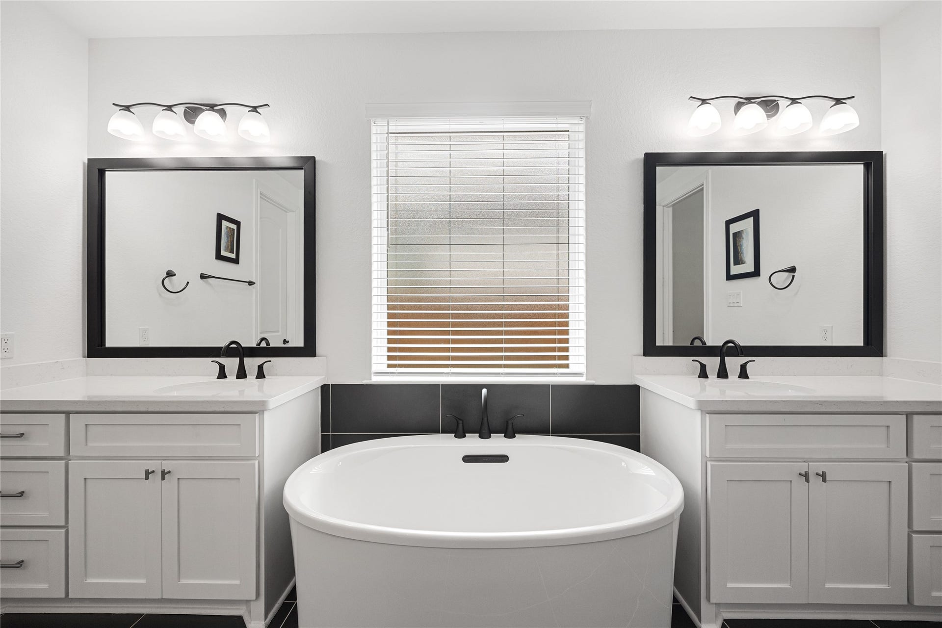 Dual sinks and large soaking tub with elevated finishes.