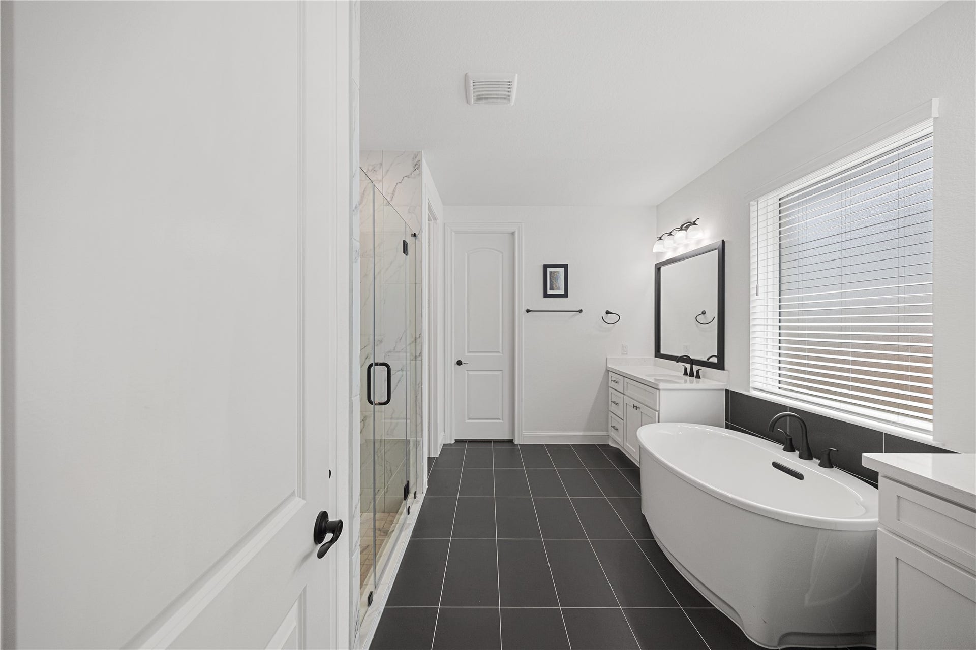 Dual sinks and large soaking tub with elevated finishes.