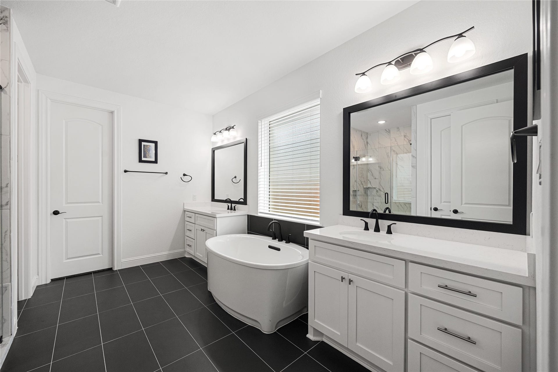 Dual sinks and large soaking tub with elevated finishes.