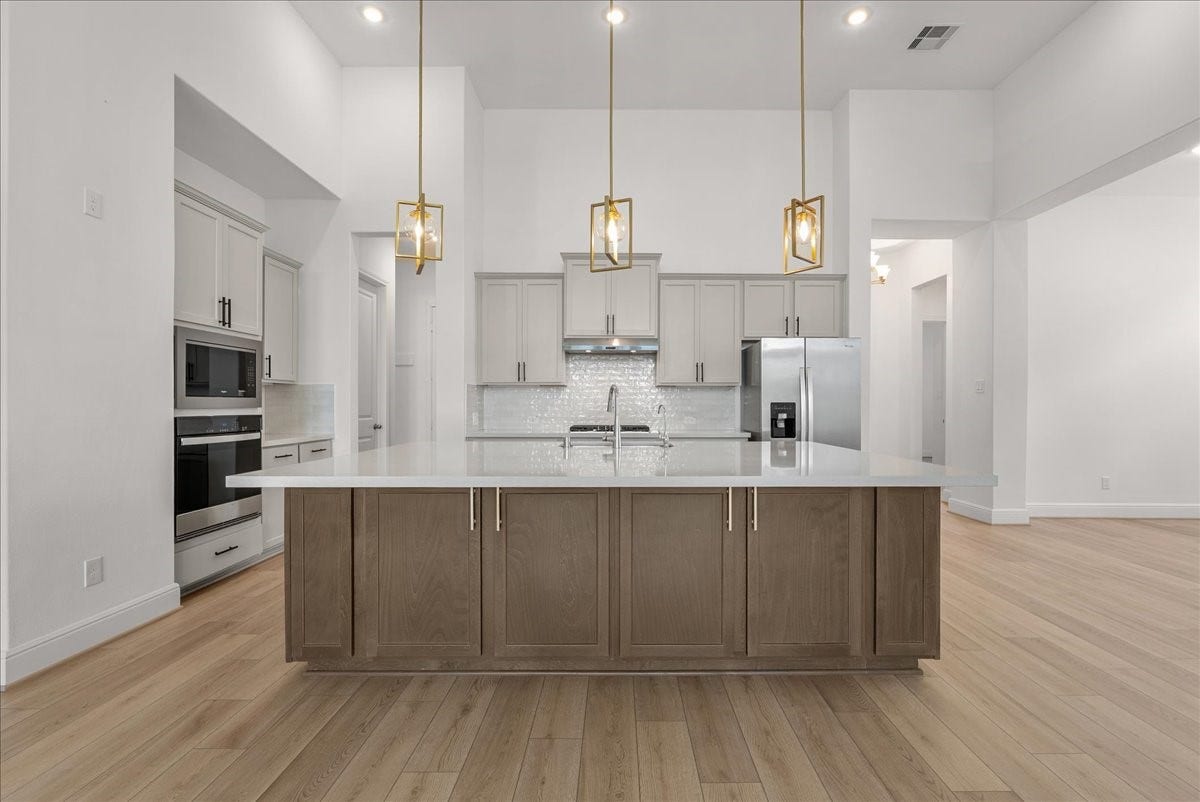 4816 Blue Pearl Lane, League City, TX 77573 The beautifully appointed kitchen opens seamlessly to the living room and features an oversized island, stainless steel appliances, and 42-inch cabinetry with crown molding.