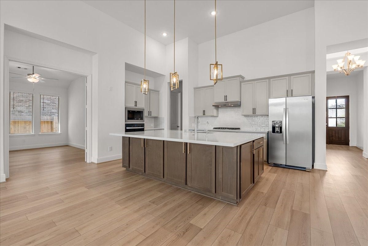 4816 Blue Pearl Lane, League City, TX 77573 The beautifully appointed kitchen opens seamlessly to the living room and features an oversized island, stainless steel appliances, and 42-inch cabinetry with crown molding.
