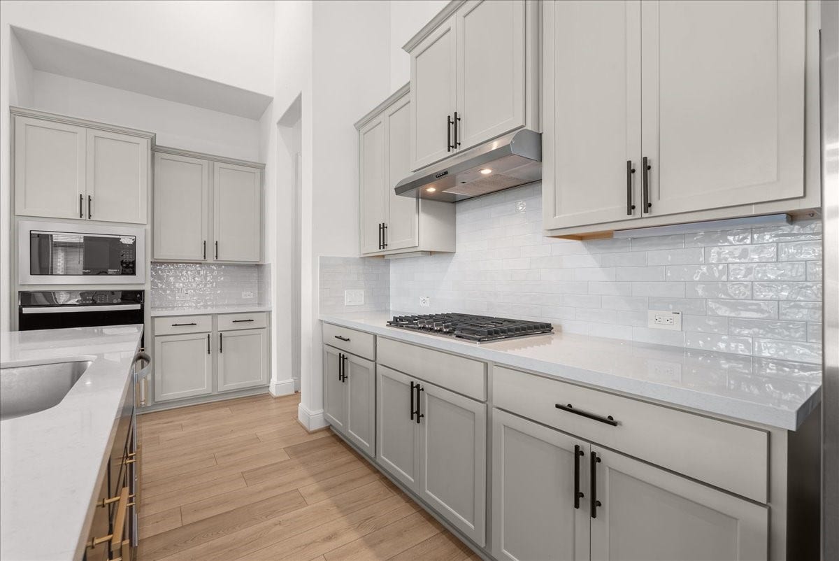 4816 Blue Pearl Lane, League City, TX 77573 The beautifully appointed kitchen opens seamlessly to the living room and features an oversized island, stainless steel appliances, and 42-inch cabinetry with crown molding.