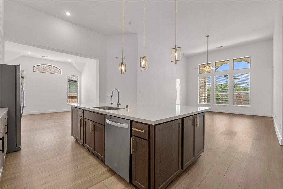 4816 Blue Pearl Lane, League City, TX 77573 The beautifully appointed kitchen opens seamlessly to the living room and features an oversized island, stainless steel appliances, and 42-inch cabinetry with crown molding.