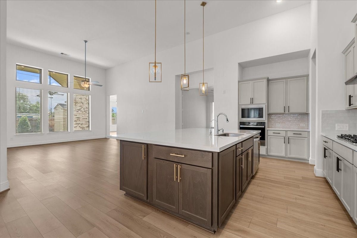 4816 Blue Pearl Lane, League City, TX 77573 The beautifully appointed kitchen opens seamlessly to the living room and features an oversized island, stainless steel appliances, and 42-inch cabinetry with crown molding.
