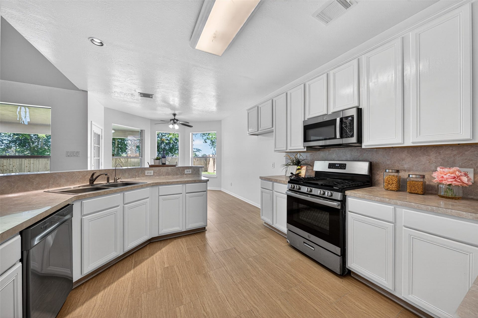 13910 Sunset View Drive, Houston, TX 77083 The chef-inspired kitchen features an abundance of pristine white cabinetry contrasted by elegant granite countertops.