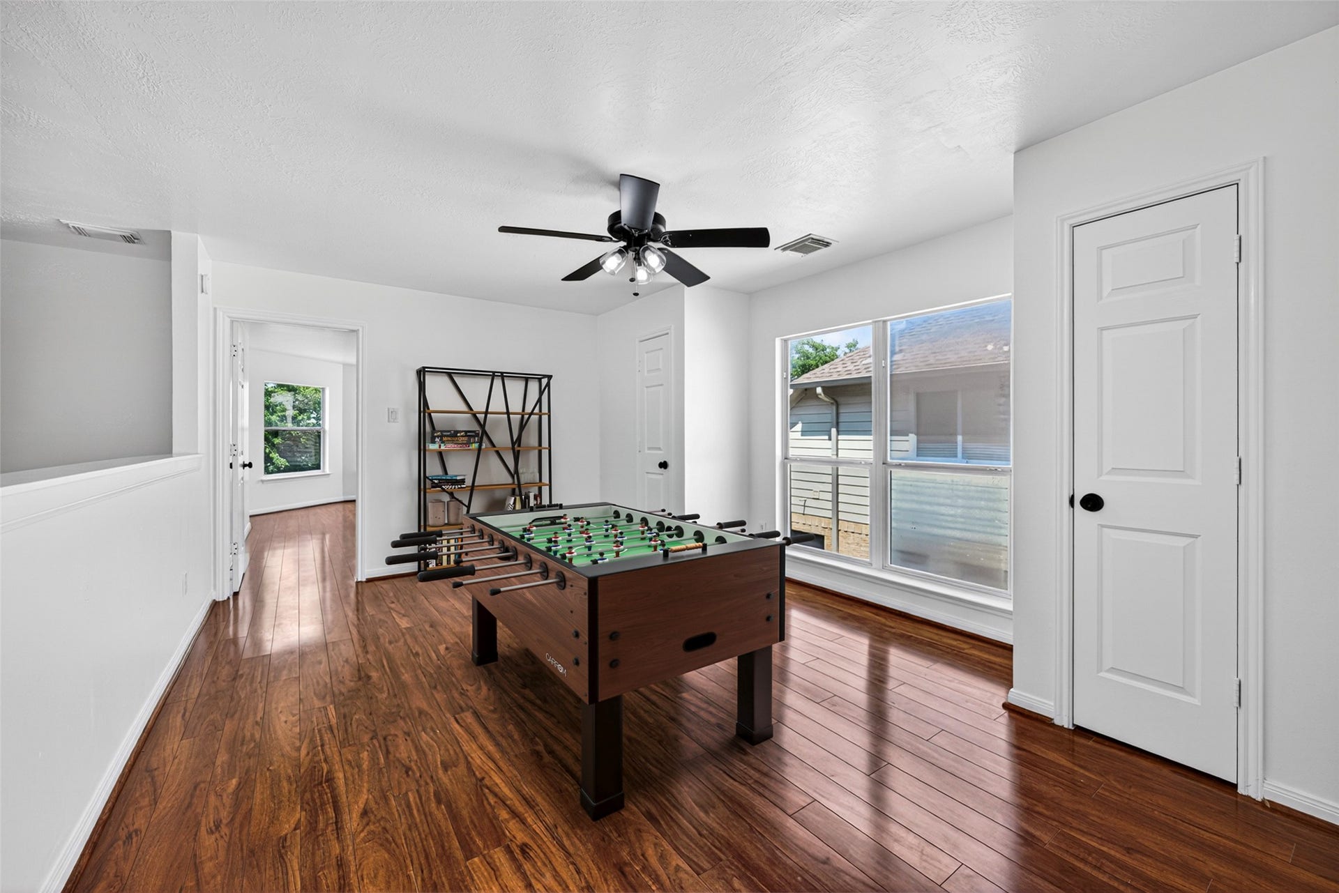 13910 Sunset View Drive, Houston, TX 77083 The versatile upstairs game room is a sprawling space anchored by rich wood flooring and bathed in natural light from large windows.