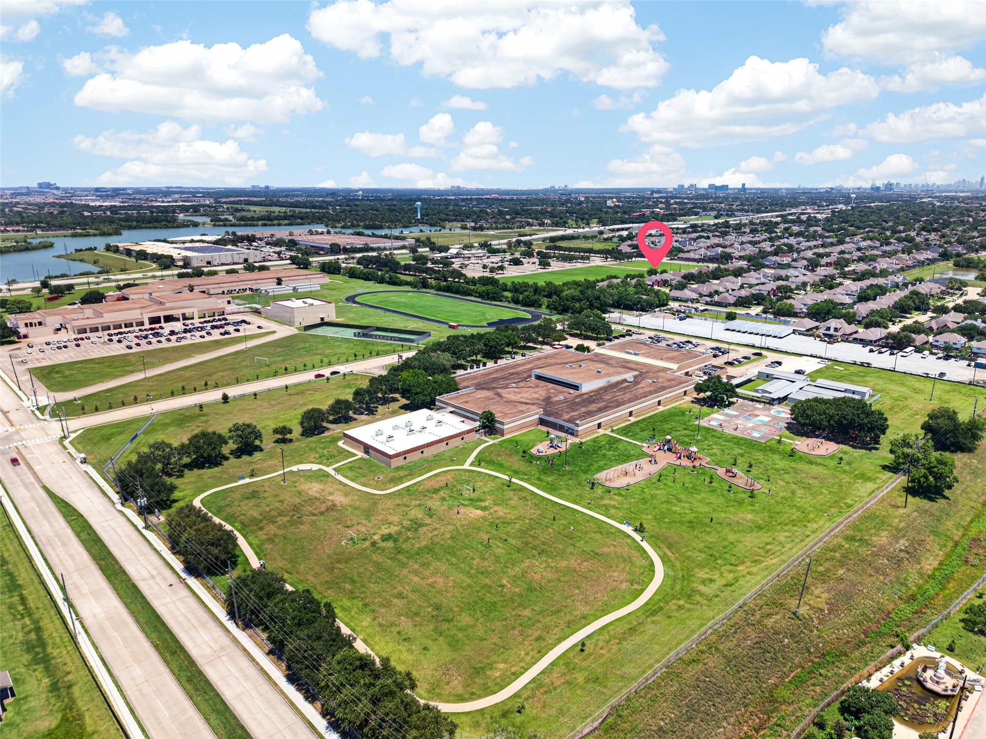 13910 Sunset View Drive, Houston, TX 77083 This expansive aerial view highlights the home's incredible location, situated within walking distance of local schools, extensive playgrounds, and sprawling green spaces.