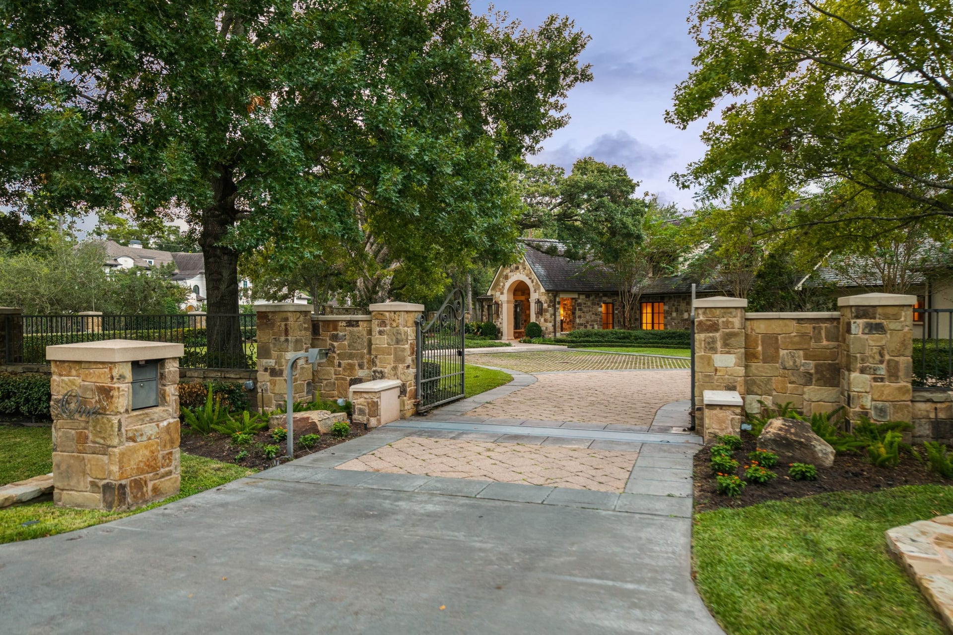 1 Gage Court, Houston, TX 77024 Stone columns and a commercial-grade gated entry create a secure, private arrival to the fully gated estate and motor court. Beyond the gates, a patterned paver drive with grass insets, mature landscaping and substantial stonework reinforce the homes architectural character and sense of arrival.