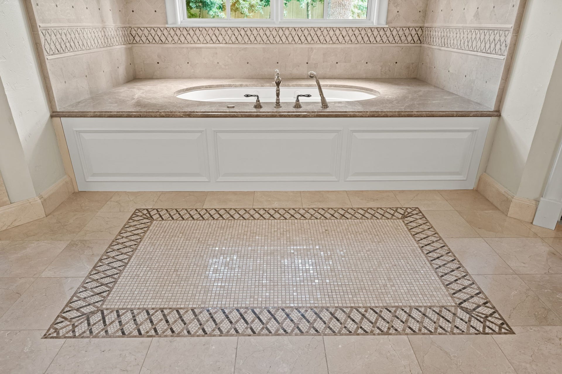 1 Gage Court, Houston, TX 77024 Heated marble flooring and a decorative mosaic inlay frame the jetted soaking tub, giving the space a refined architectural focal point. Detailed stonework throughout adds another layer of craftsmanship to the suite.