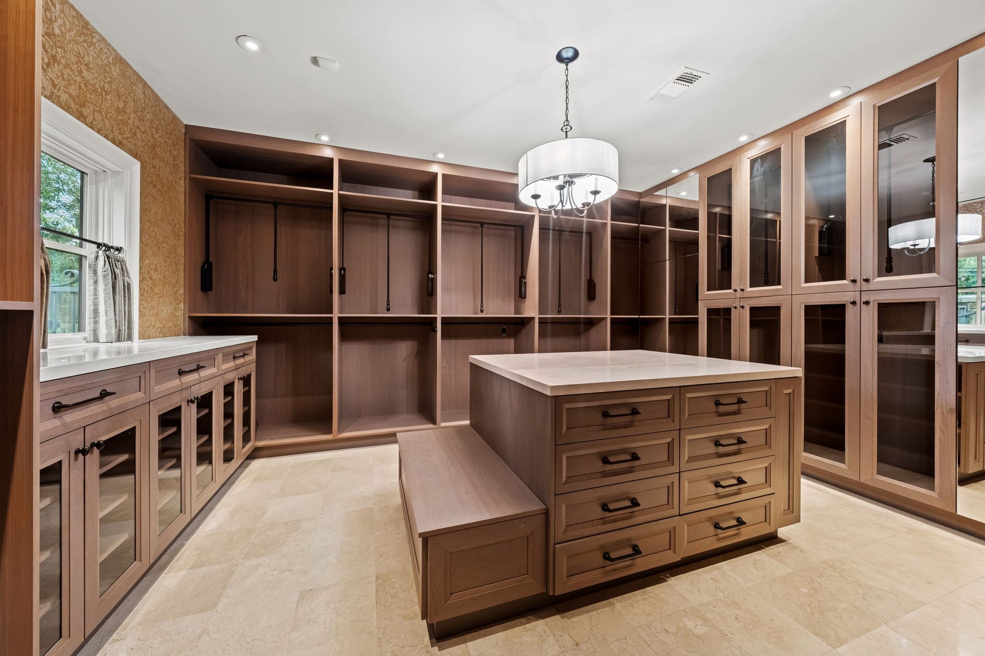 1 Gage Court, Houston, TX 77024 One of the three primary dressing rooms features extensive California Closets cabinetry and a large packing island for additional storage. The room is designed as a true dressing space rather than simply a walk-in closet.