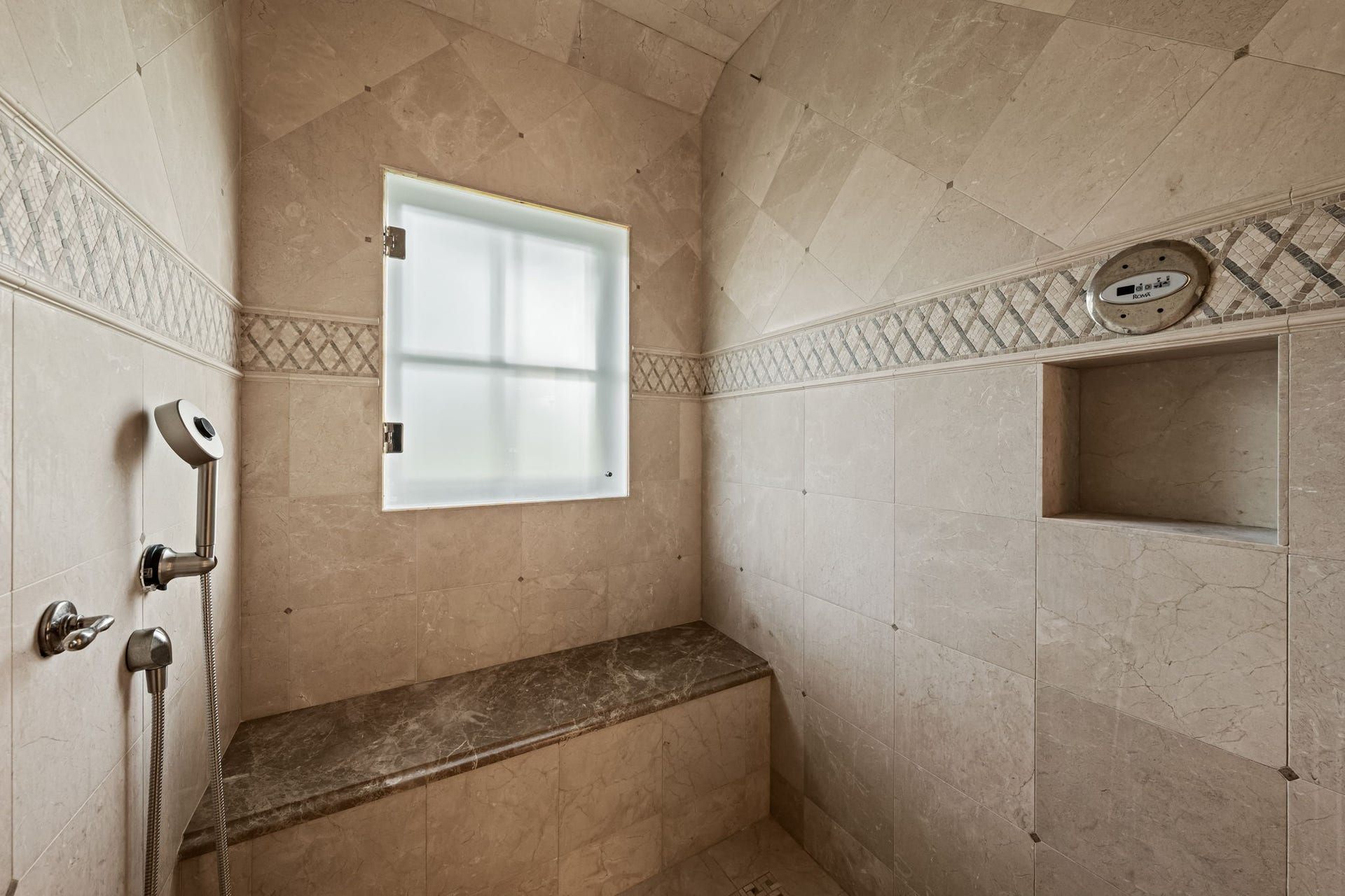 1 Gage Court, Houston, TX 77024 The Roma steam shower is finished in marble with a frameless glass enclosure, built-in bench and rainfall shower fixture. A frosted window brings in natural light while maintaining privacy.