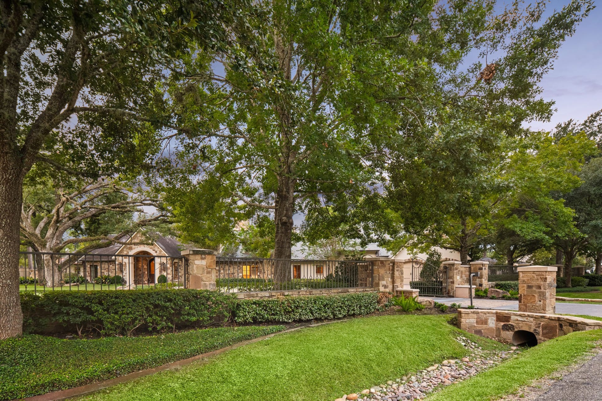 1 Gage Court, Houston, TX 77024 The fully gated estate is framed by wrought-iron fencing and substantial stone columns, with additional stone detailing carried throughout the driveway and motor court area. The broad approach provides generous guest parking, easy circulation and access to the attached two-car garage.
