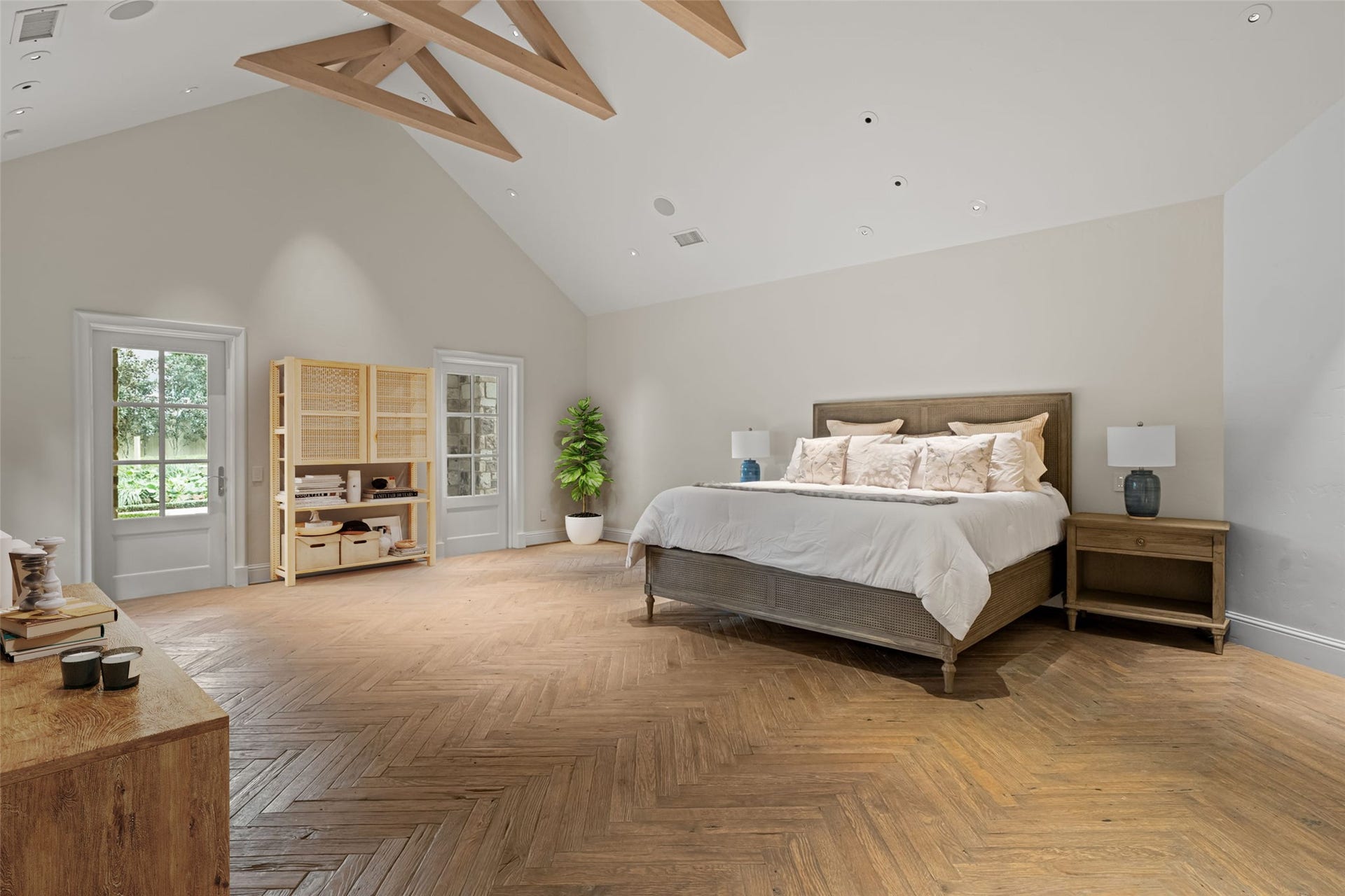 1 Gage Court, Houston, TX 77024 The primary bedroom includes direct access to the outdoor hot tub and backyard living areas, creating a private connection to the homes resort-style setting. Multiple windows bring in natural light while maintaining views toward the grounds.