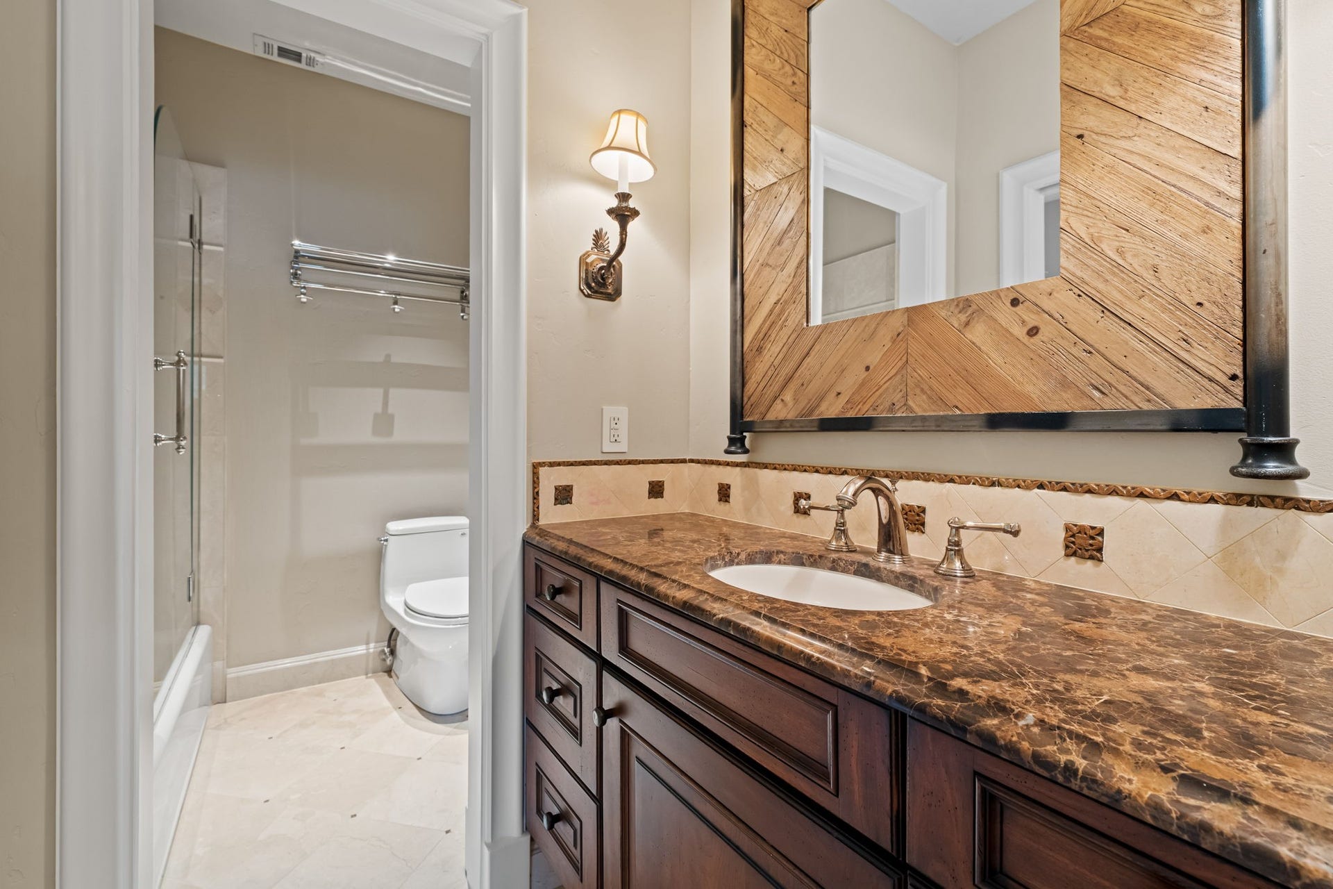 1 Gage Court, Houston, TX 77024 The en suite bath features marble flooring, glazed subway tile wainscoting and a furniture-style vanity with marble countertop. A framed mirror and paired sconces complete the tailored finish.