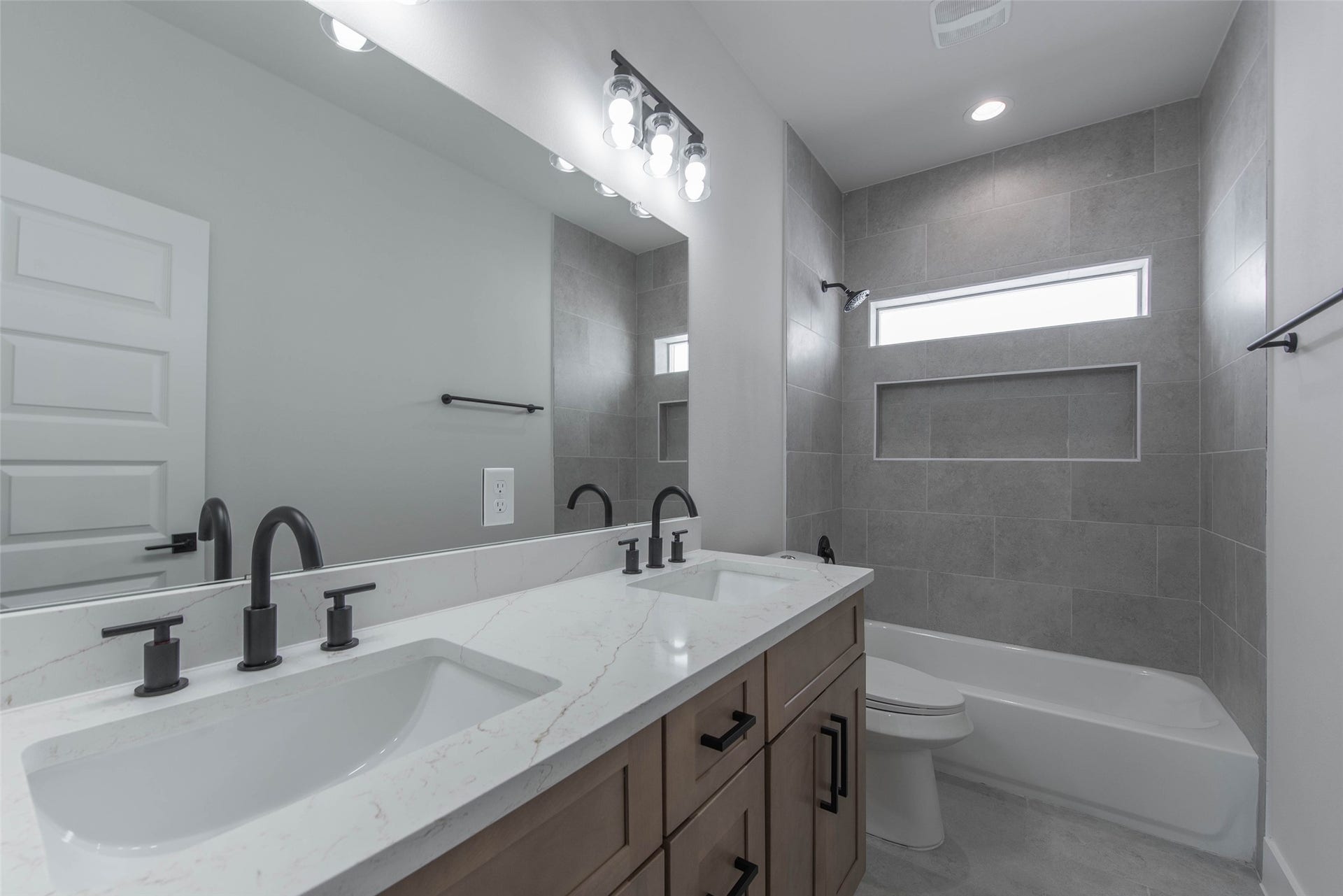 The secondary bath features dual vanities, ample storage, and a tub-shower combo, offering both comfort and functionality.