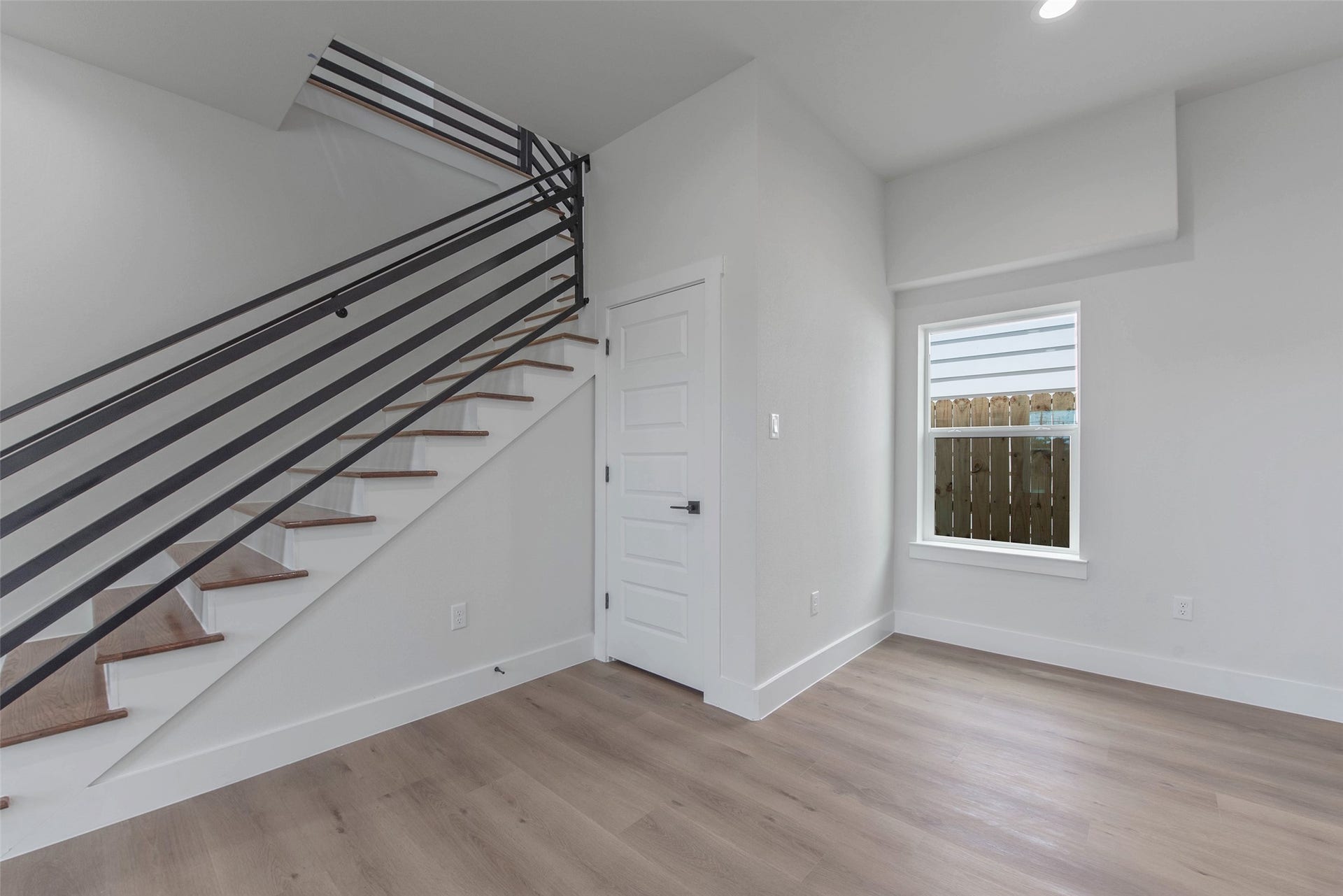 Wrought iron-accented stairs lead you to an inviting upstairs flex space, offering versatility, space, and style.