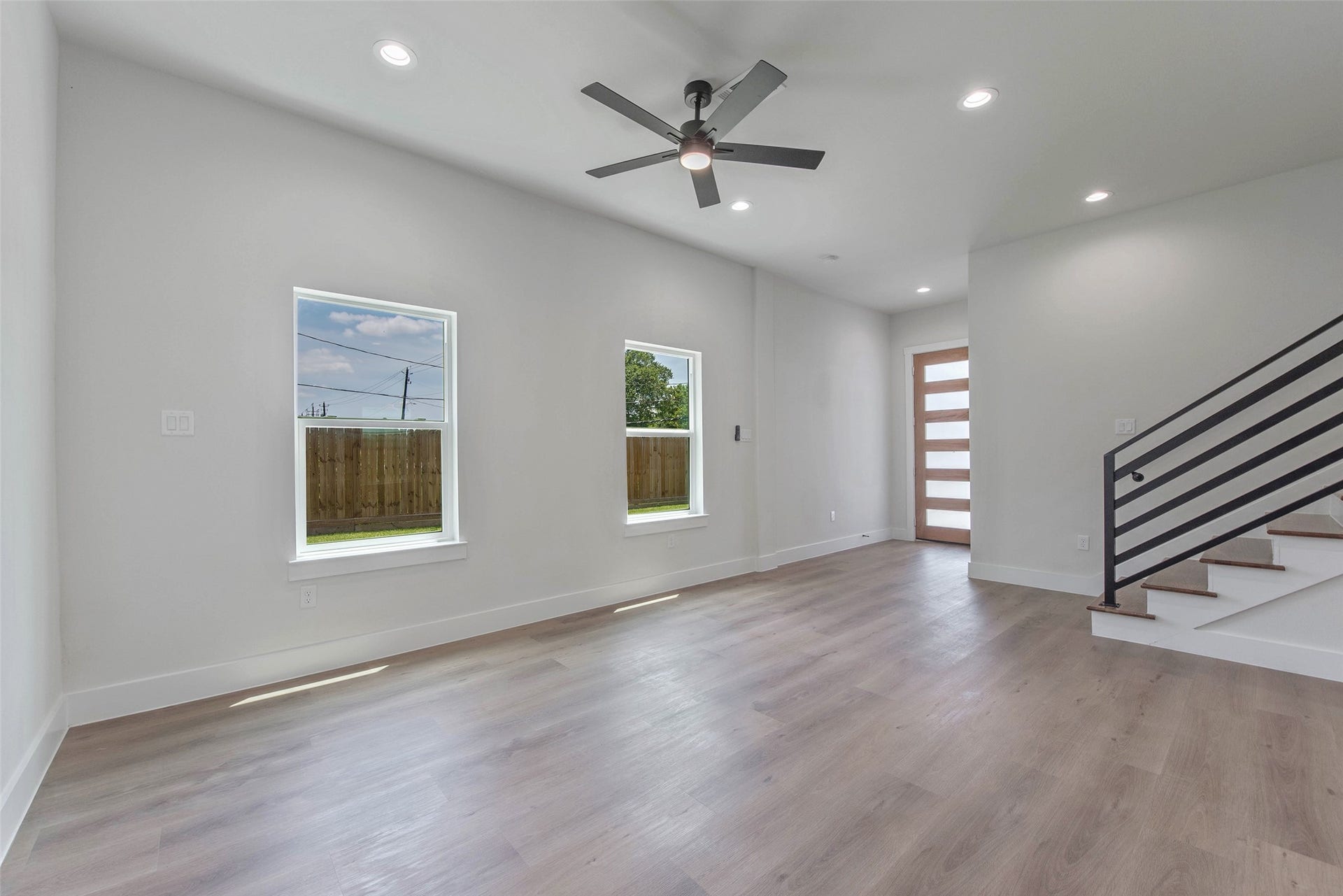 A view from the kitchen captures the seamless flow between the living room and entryway, while the staircase leads upstairs to the bedrooms, baths, and versatile flex space.