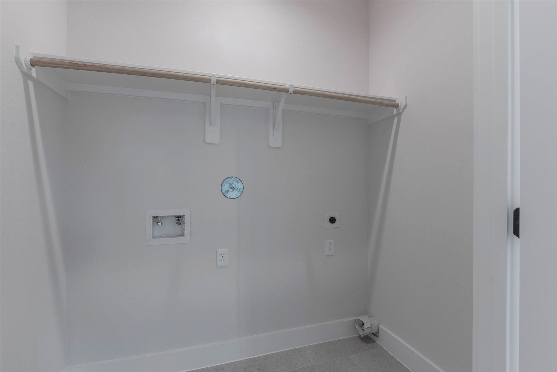 A spacious utility closet located off the flex space, offering ample storage for household essentials and a dedicated washer and dryer area for added convenience.