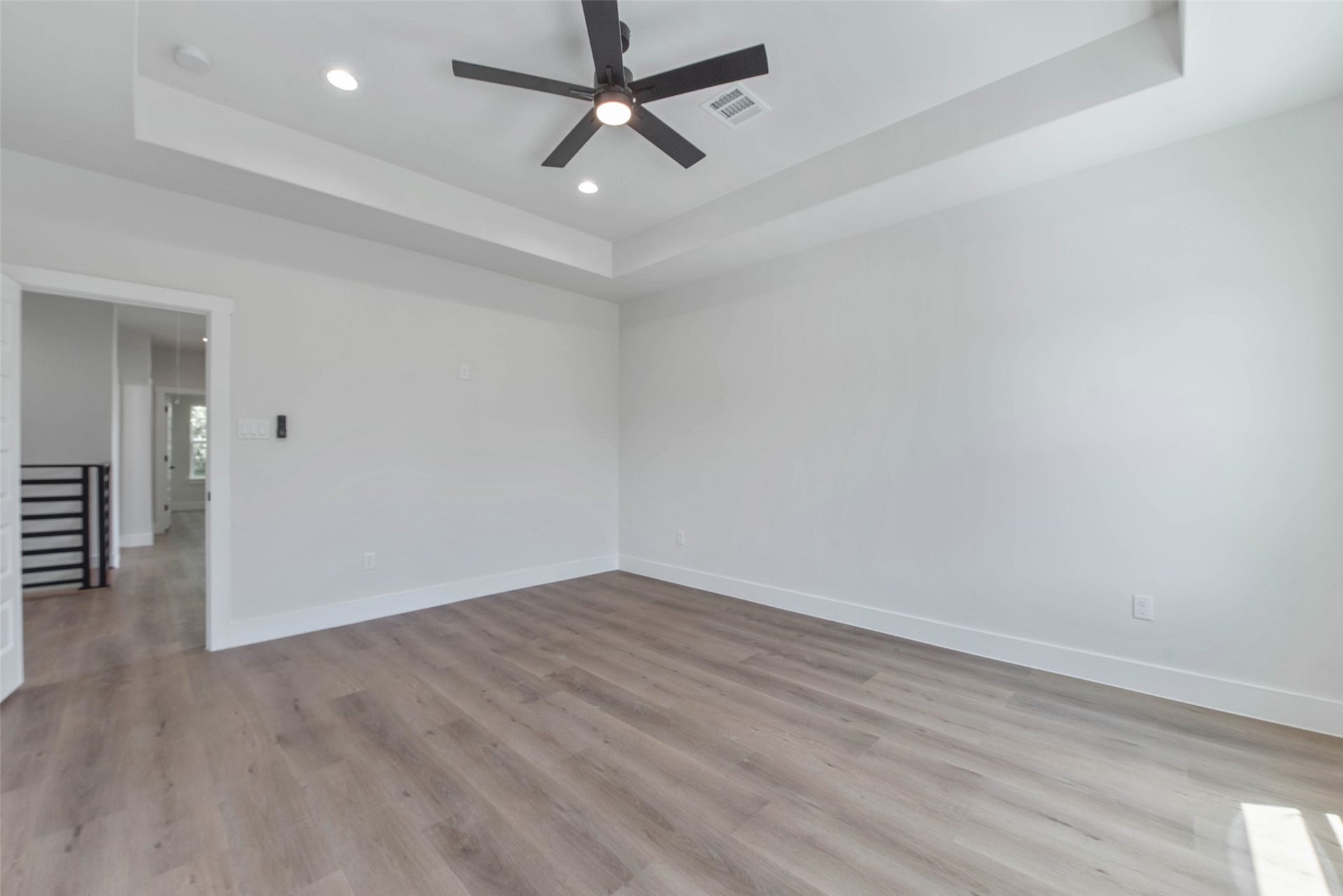 The primary bedroom features a beautifully recessed ceiling, adding depth and architectural interest to the space.