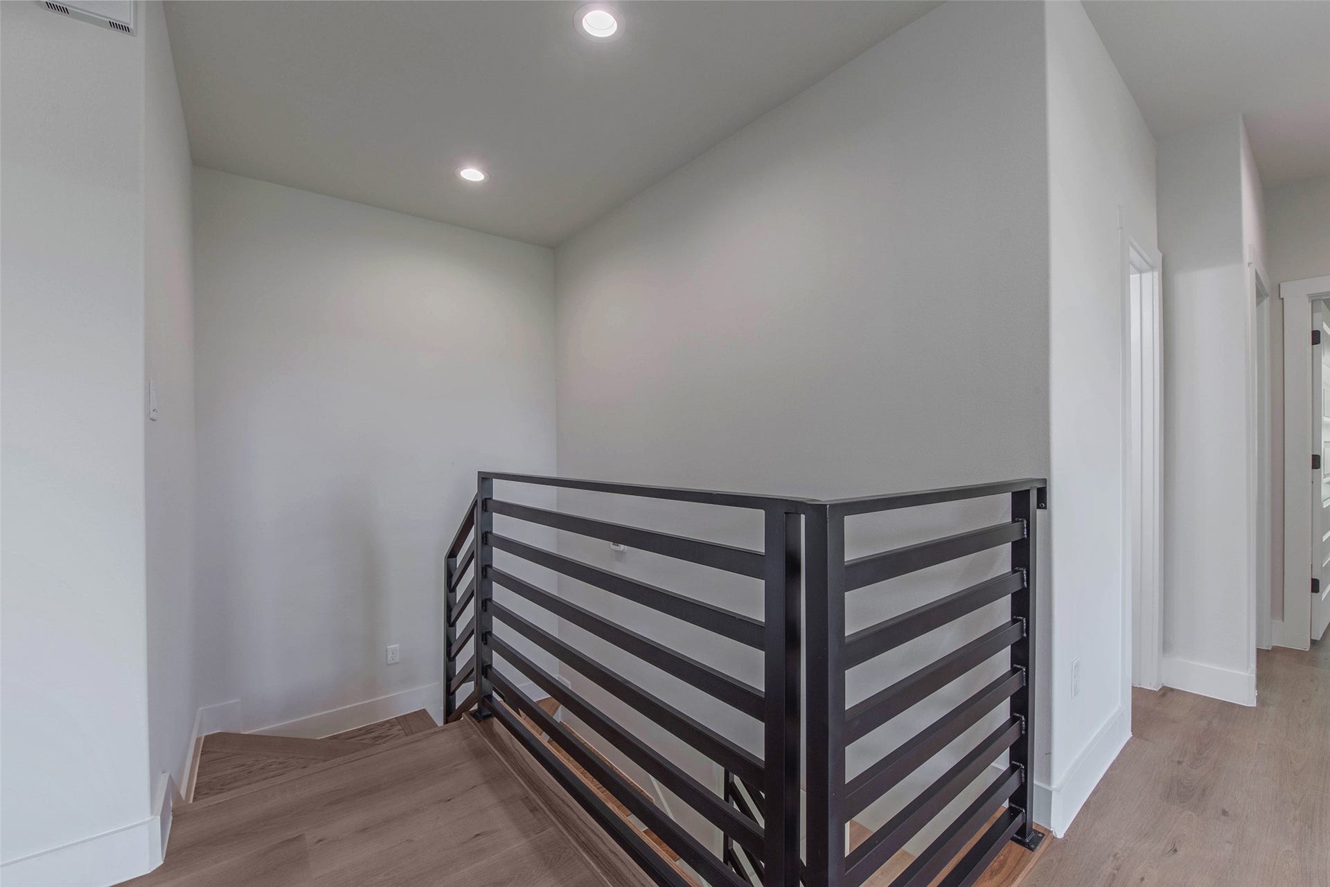 The staircase has a light, airy design that enhances the homes modern flow and openness.
