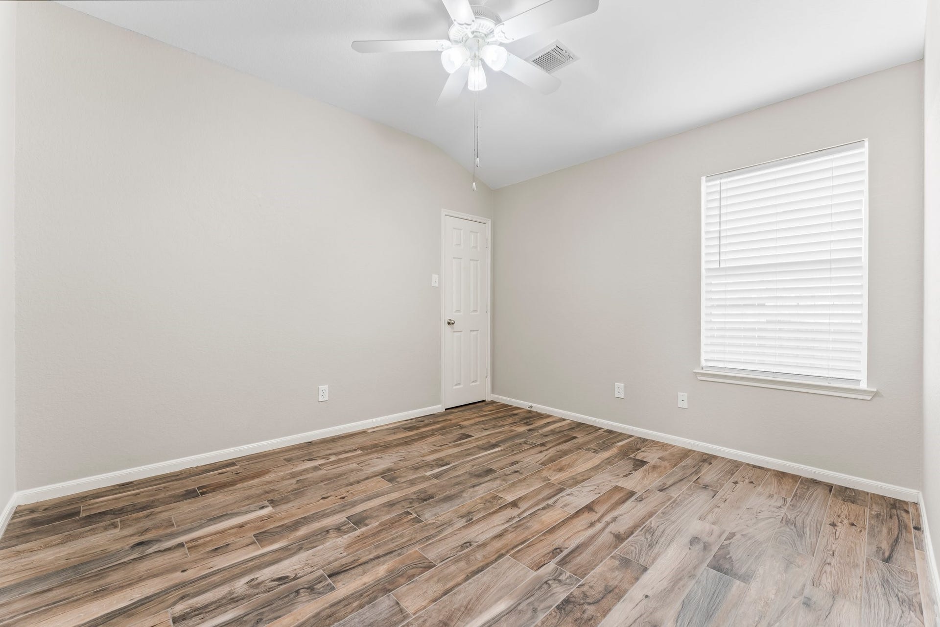 34 Bryce Branch Circle, The Woodlands, TX 77382 A secondary bedroom offers wood-look ceramic tile flooring, fresh paint, large walk-in closet, sunny window, and lighted ceiling fan. It has hallway access to a full bath.