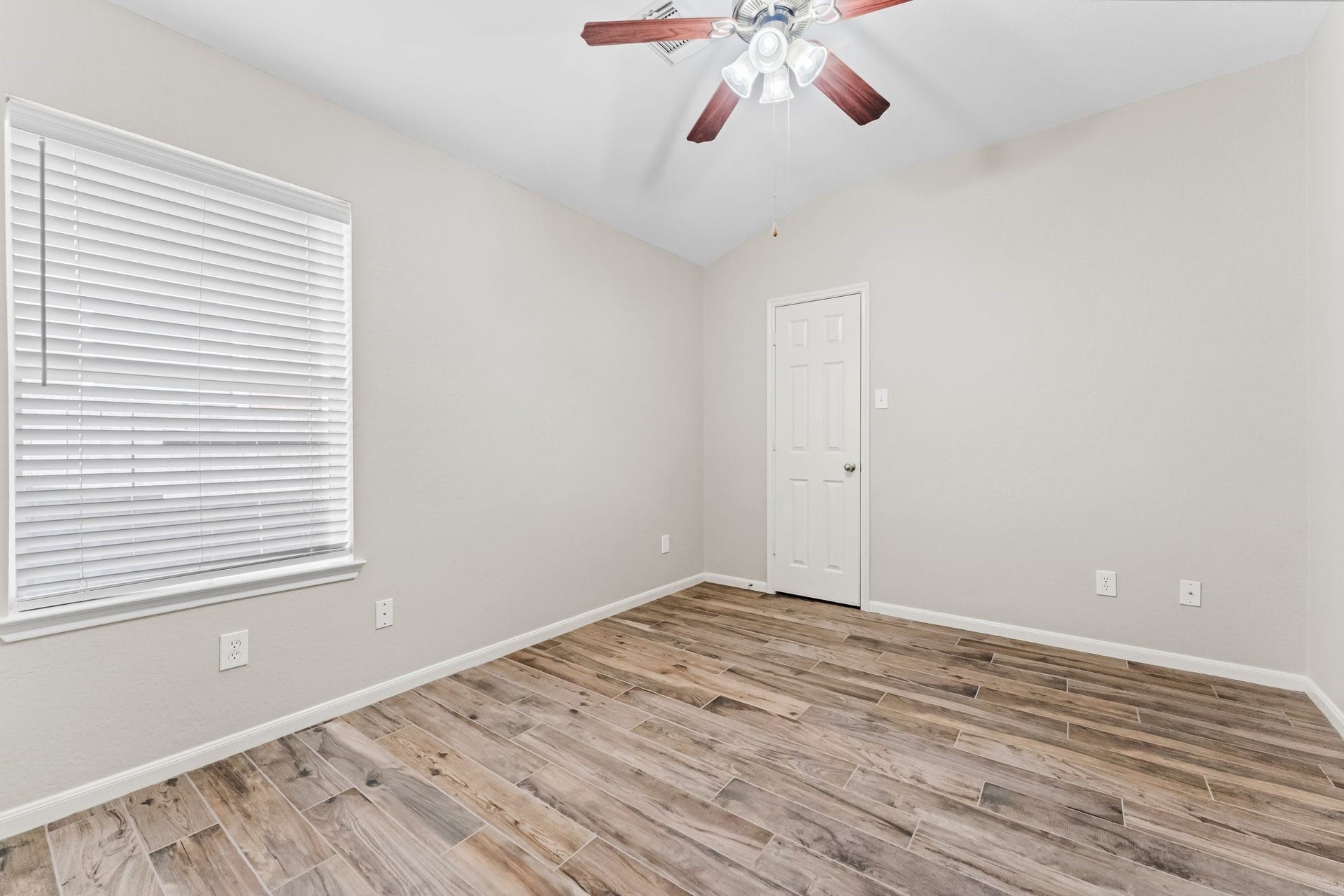 34 Bryce Branch Circle, The Woodlands, TX 77382 A secondary bedroom offers wood-look ceramic tile flooring, fresh paint, large walk-in closet, sunny window, and lighted ceiling fan. It has hallway access to a full bath.