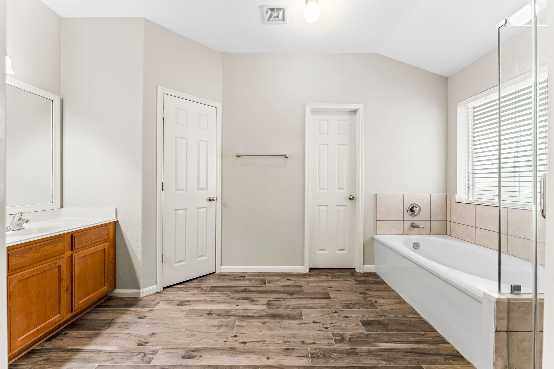34 Bryce Branch Circle, The Woodlands, TX 77382 Truly a retreat for getting ready on a busy morning or stealing away for an evening out. Your calming en-suite bath features an elegant double door entry, wood-look ceramic tile flooring, giant soaking tub, huge shower, sunny frosted window, linen cabinet, large walk-in closet, private commode, and framed mirror.