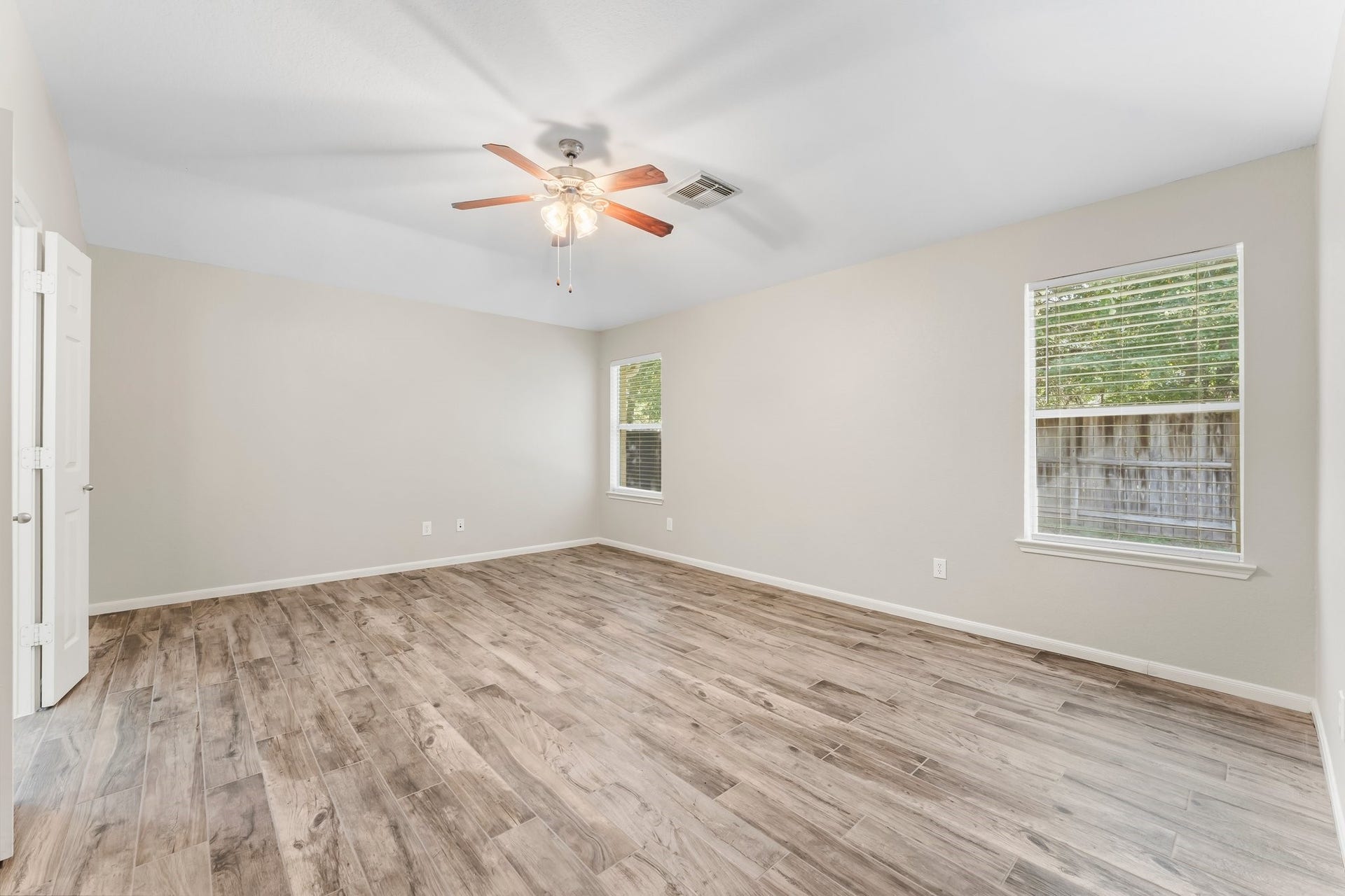 34 Bryce Branch Circle, The Woodlands, TX 77382 The primary suite has high ceilings, wood-look ceramic tile flooring, fresh paint, lighted ceiling fan, two sunny windows, and gorgeous back yard views of the greenbelt!