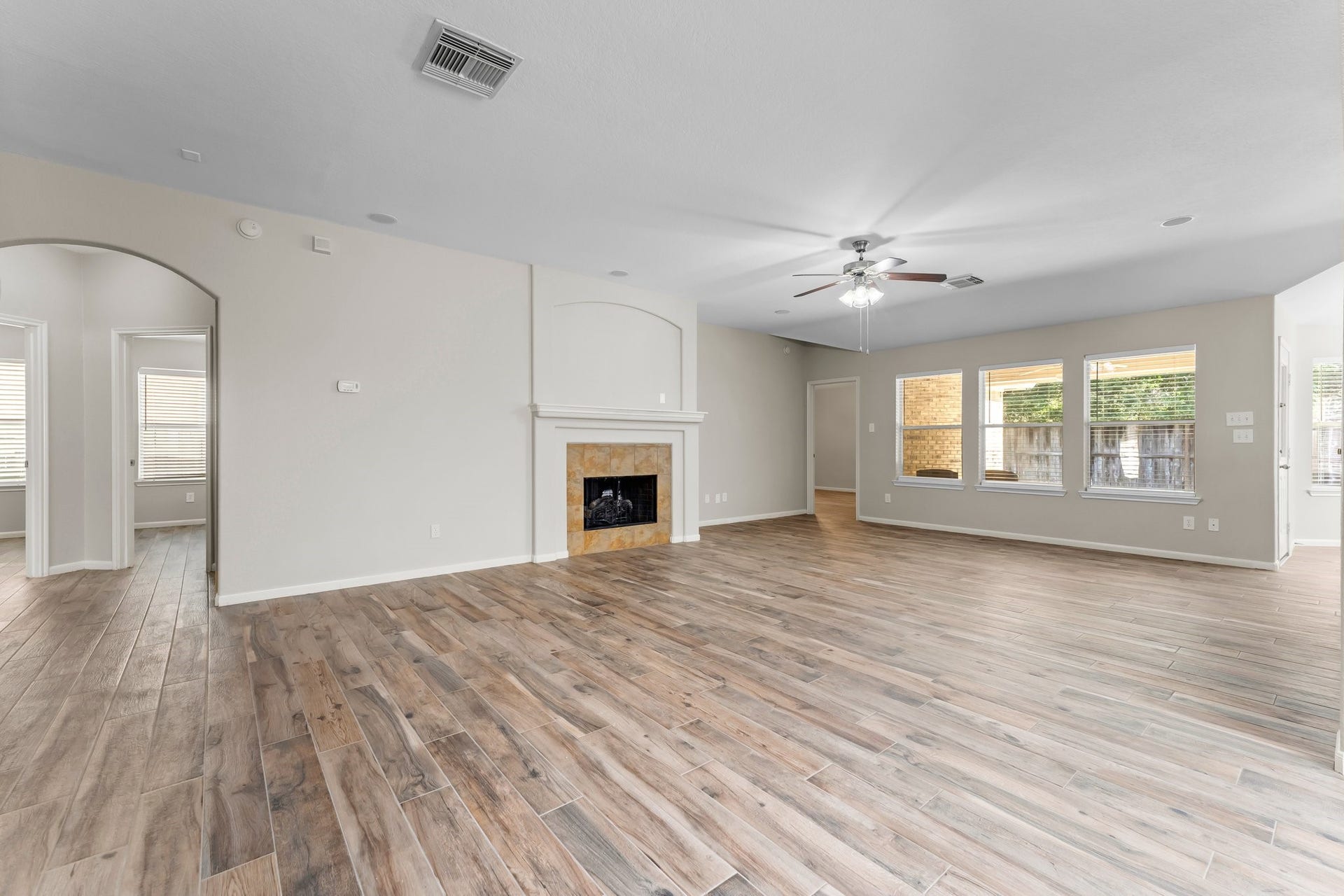34 Bryce Branch Circle, The Woodlands, TX 77382 Fabulous open concept Family Room/Den with warm flooring and plenty of natural light with a wall of windows looking out to the private back yard! The fireplace features an arched niche for your TV or art.