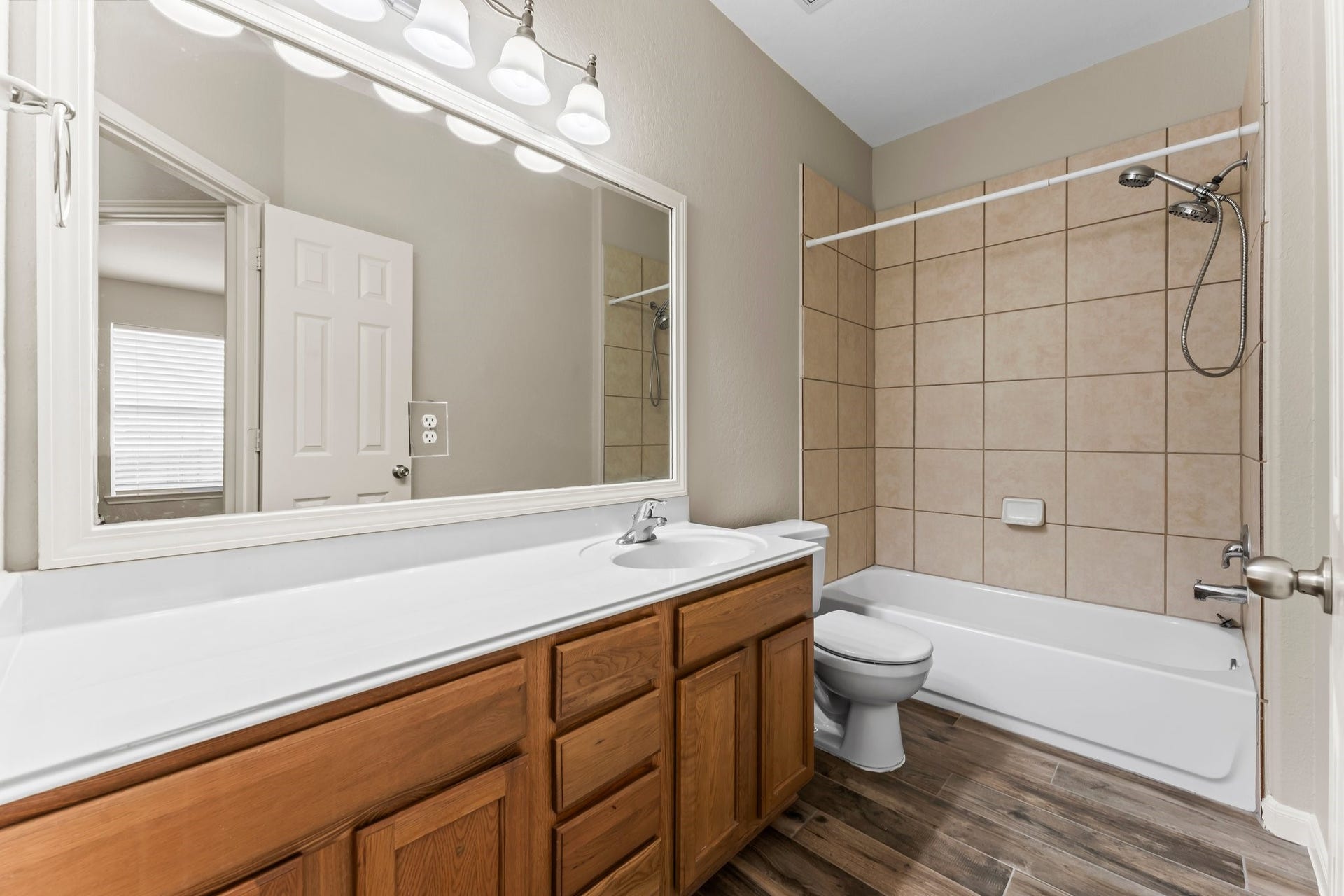 34 Bryce Branch Circle, The Woodlands, TX 77382 Large second bathroom with extended countertop, toilet, framed mirror, and tiled shower/tub combo.
