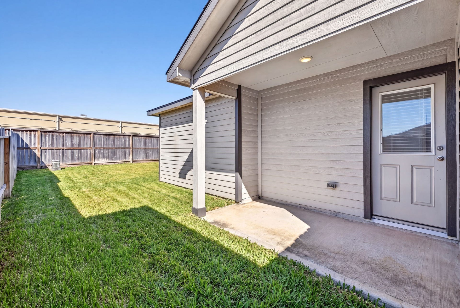 5243 Shallowhurst Lane, Katy, TX 77449 BACKYARD - A covered back patio with an overhead light, a perfect spot for morning coffee or evening grilling.