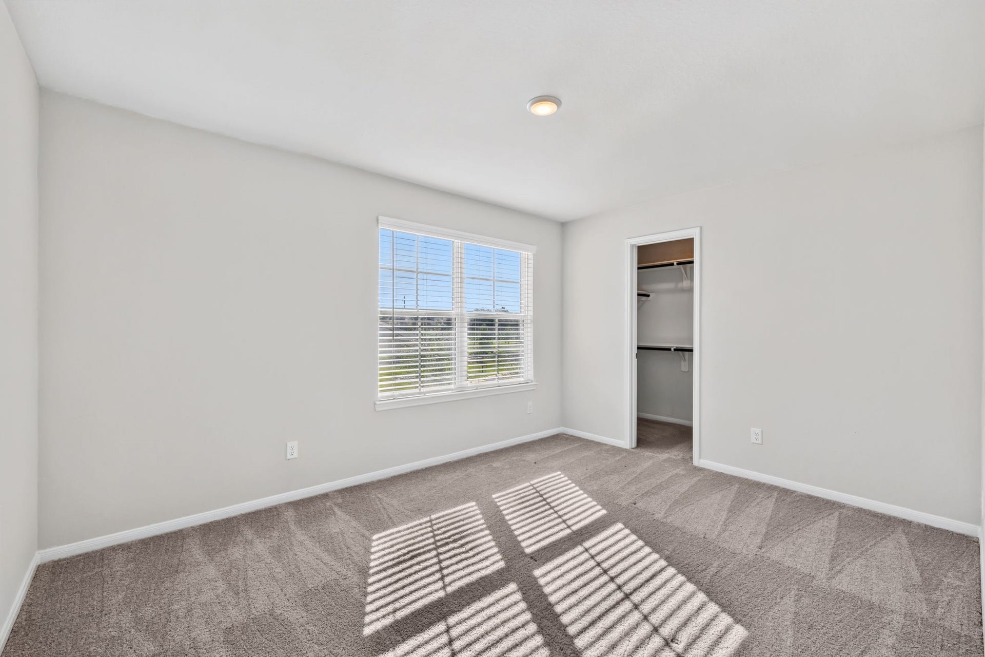 5243 Shallowhurst Lane, Katy, TX 77449 SECOND BEDROOM - A bright secondary bedroom with plush carpet, a large window, and a walk-in closet.