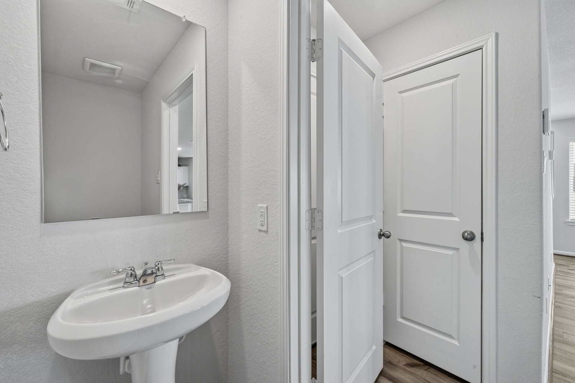 5243 Shallowhurst Lane, Katy, TX 77449 HALF BATH - A convenient first-floor half bath with a pedestal sink and a decorative mirror, just off the main living area.