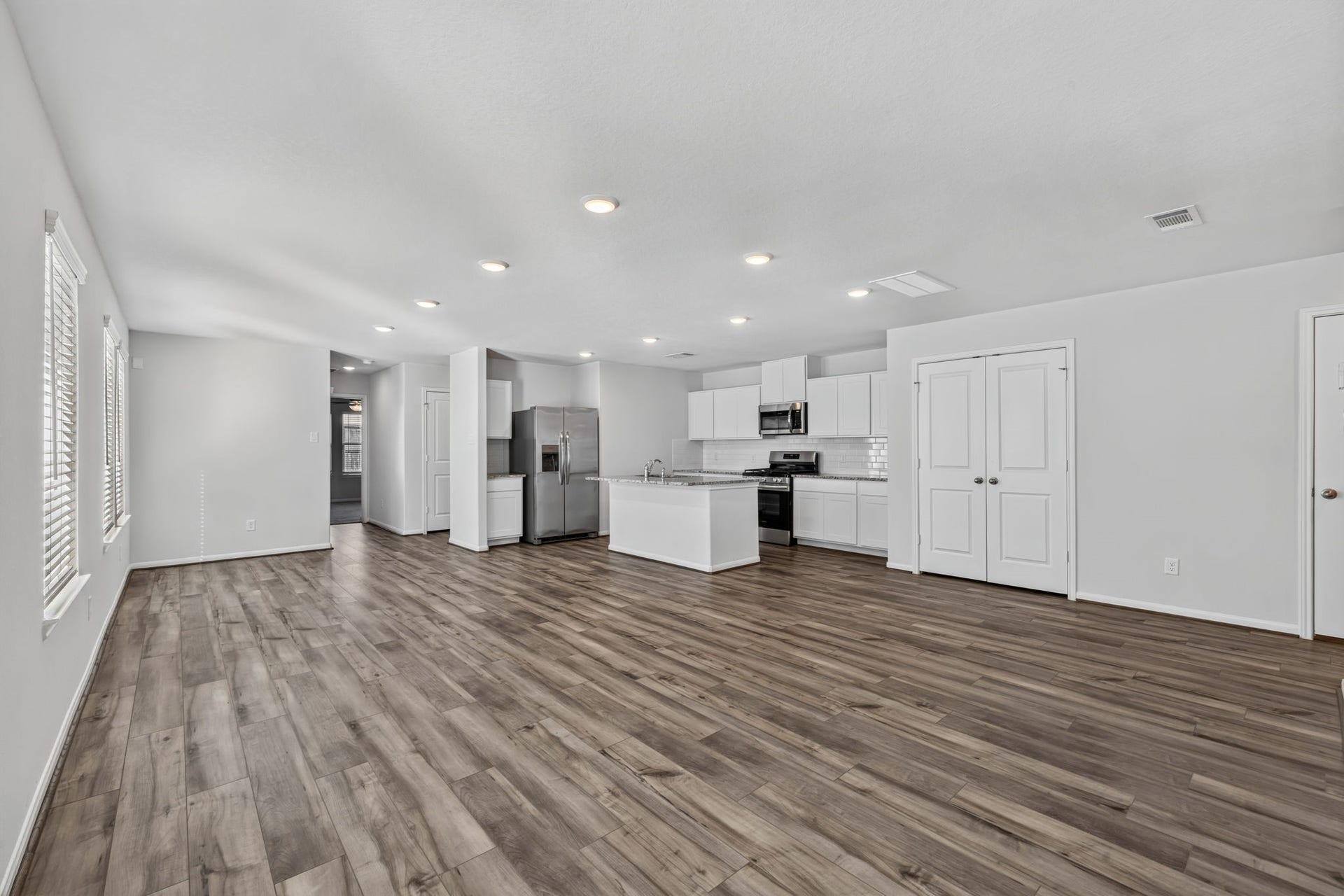 5243 Shallowhurst Lane, Katy, TX 77449 LIVING SPACE - The spacious living area has natural light, and an easy flow into the kitchen with a double door pantry and the hallway to the first-floor bedroom.