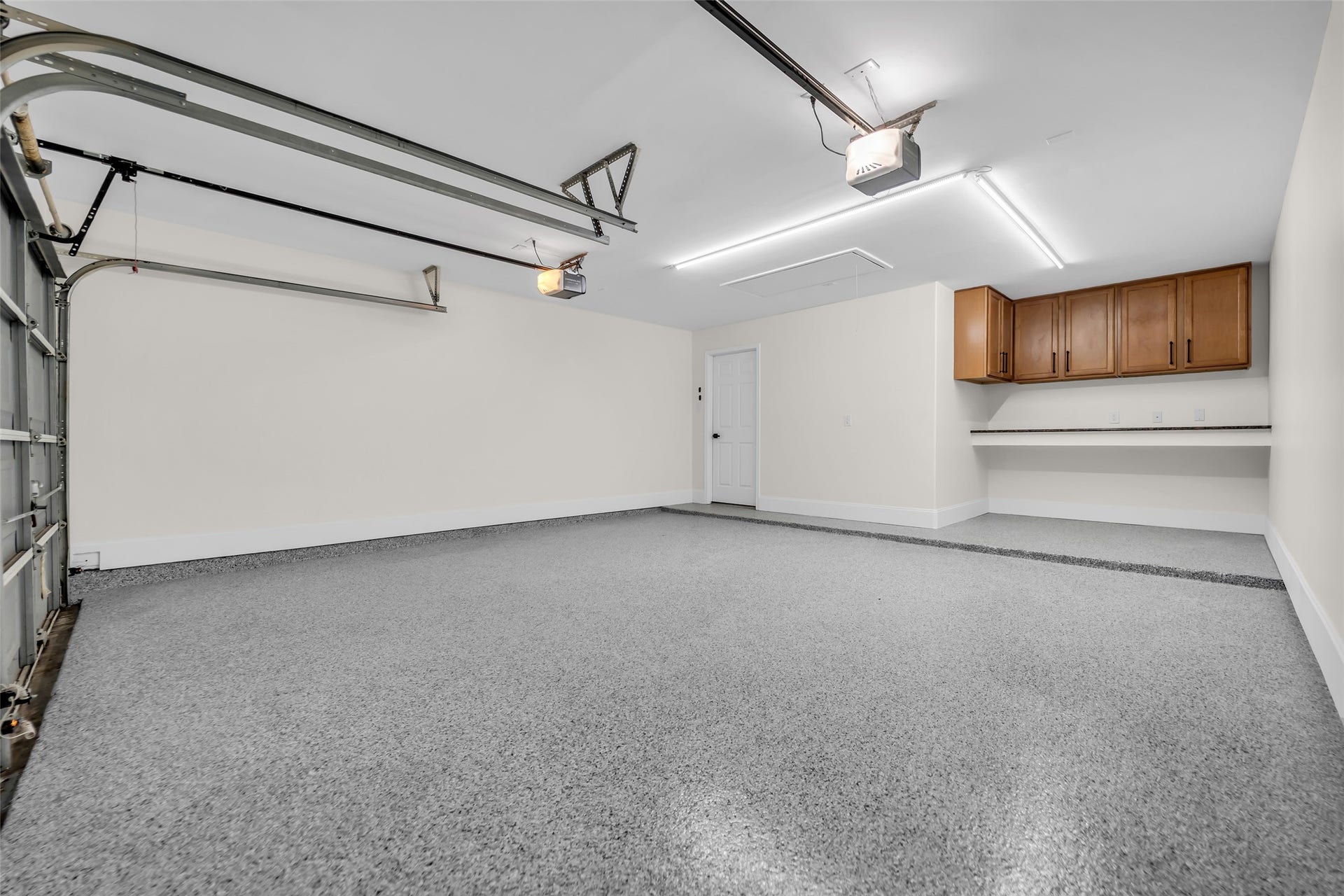 3906 Inglewood Circle, Missouri City, TX 77459 Garage features an epoxy floor and built in work space with hanging cabinetry for storage.