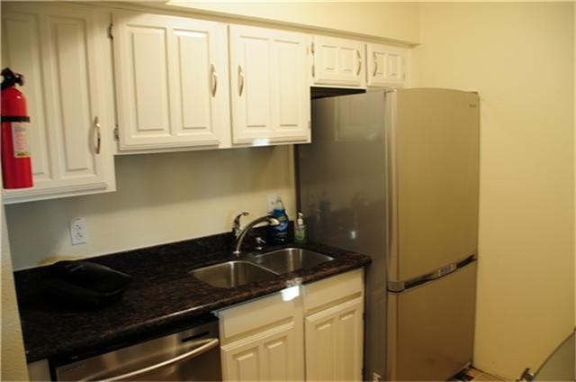 6001 Reims Road, #1202, Houston, TX 77036 This compact kitchen features white cabinetry, a dark granite countertop, stainless steel appliances, and a sleek fridge, offering a modern and efficient space.