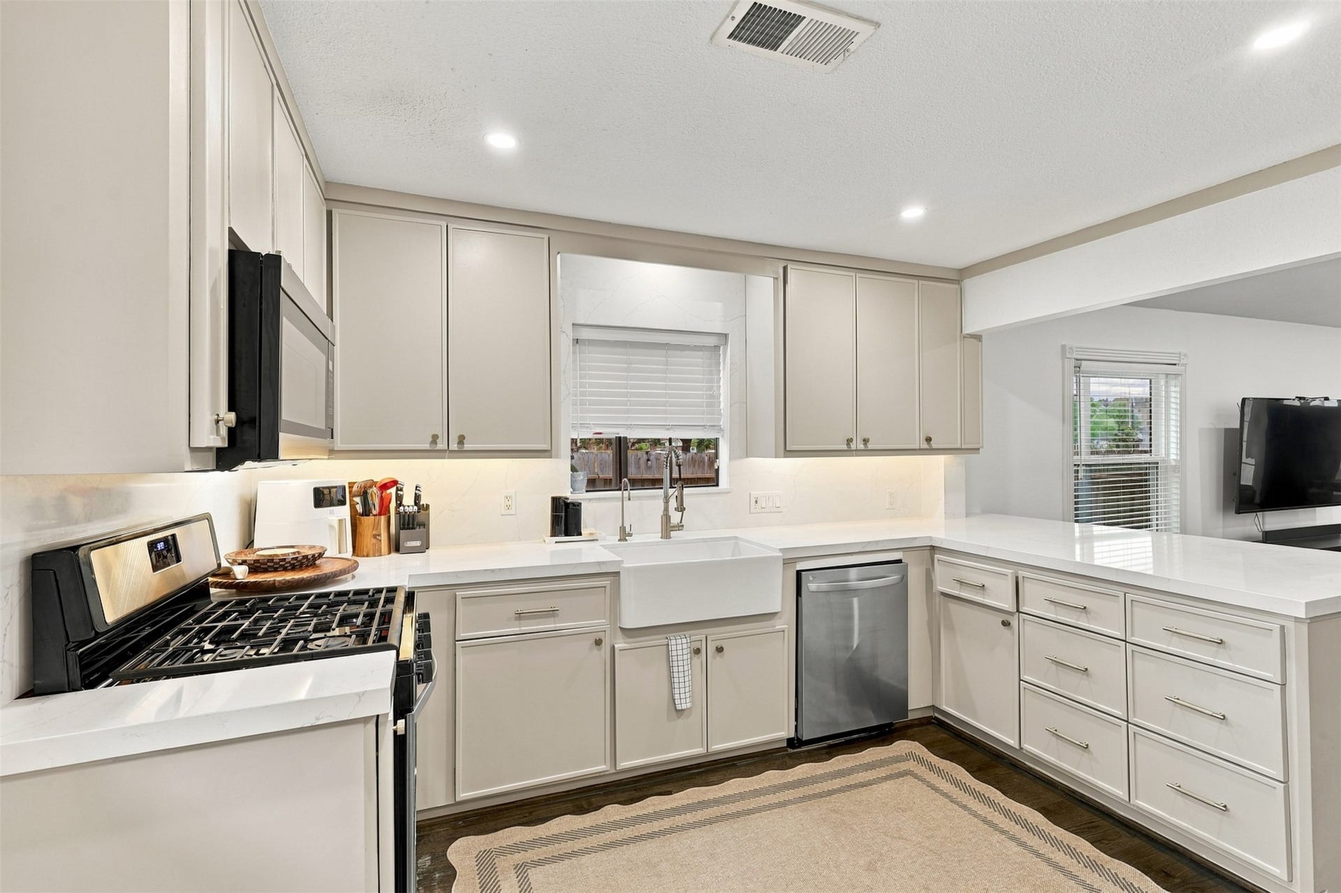 5410 Kiam Street, Houston, TX 77007 Elegant kitchen featuring sleek cabinetry, stainless steel appliances, and a spacious farmhouse sink, all complemented by a bright, open layout.