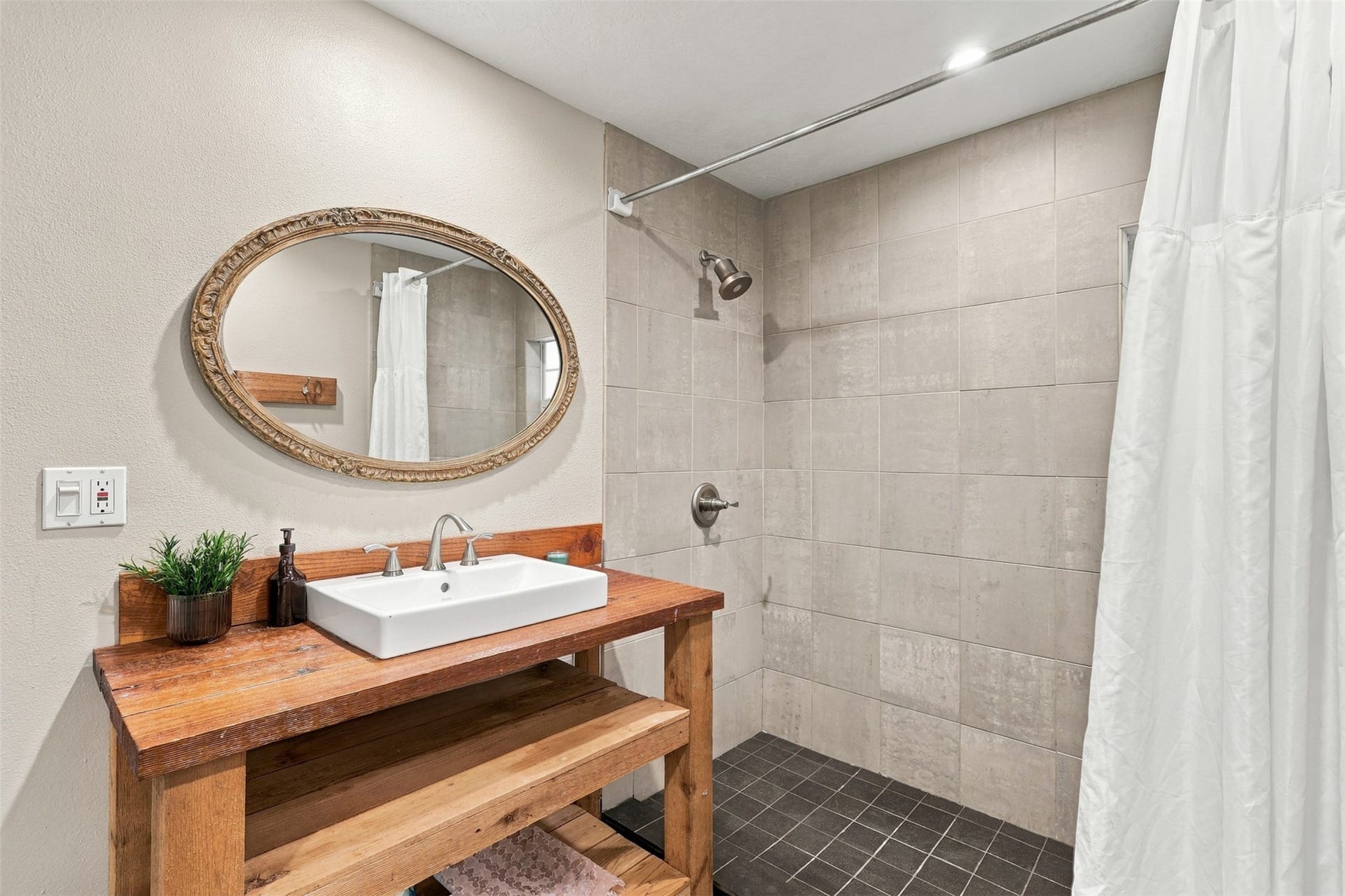 5410 Kiam Street, Houston, TX 77007 Charming bathroom with a rustic wooden vanity, stylish vessel sink, and a spacious tiled walk-in shower.