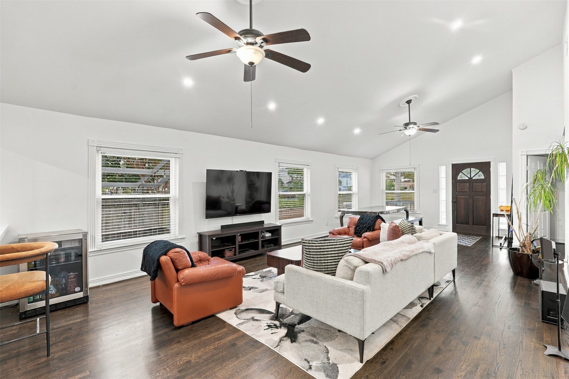 5410 Kiam Street, Houston, TX 77007 Spacious and inviting living area features high ceilings, hardwood floors, and abundant natural light from multiple windows, complemented by modern ceiling fans and a cozy seating arrangement.