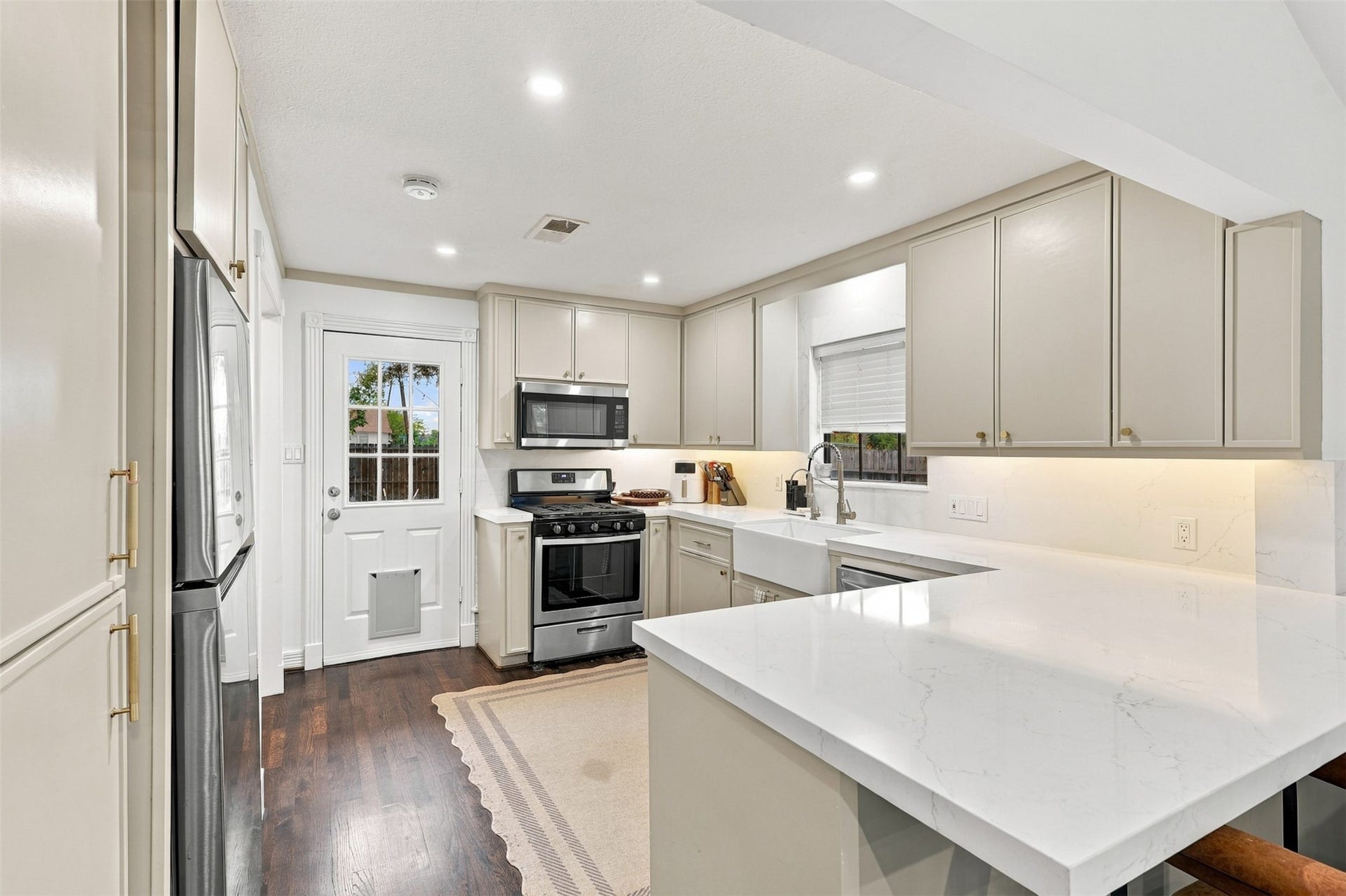 5410 Kiam Street, Houston, TX 77007 Elegant kitchen with sleek stainless steel appliances, pristine quartz countertops, and ample cabinetry, offering a modern and functional space for culinary endeavors.