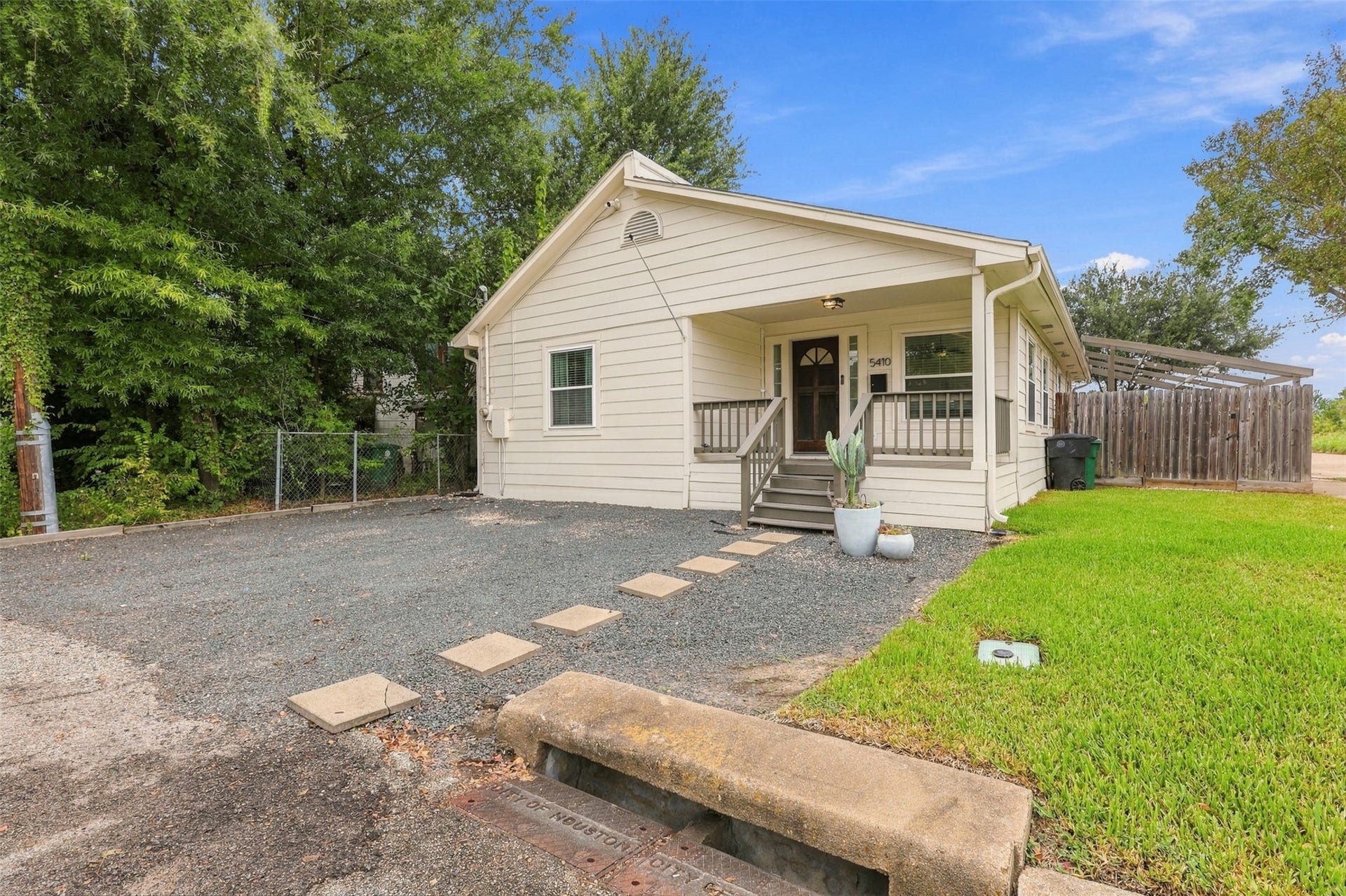 5410 Kiam Street, Houston, TX 77007 Charming single-story home with a welcoming front porch, nestled on a spacious lot with mature trees and a neatly maintained yard.