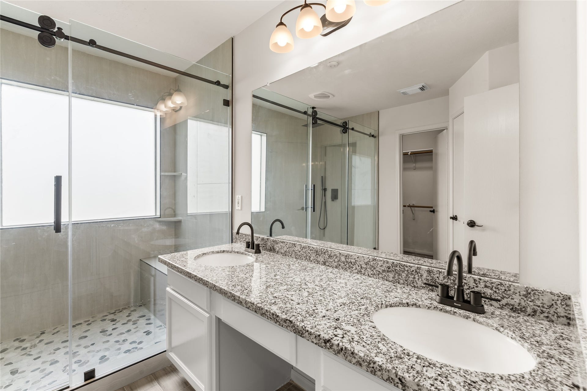 17042 Midnight Sun Lane, Richmond, TX 77407 Beautifully updated primary bathroom featuring granite countertops, dual sinks, and modern finishes.