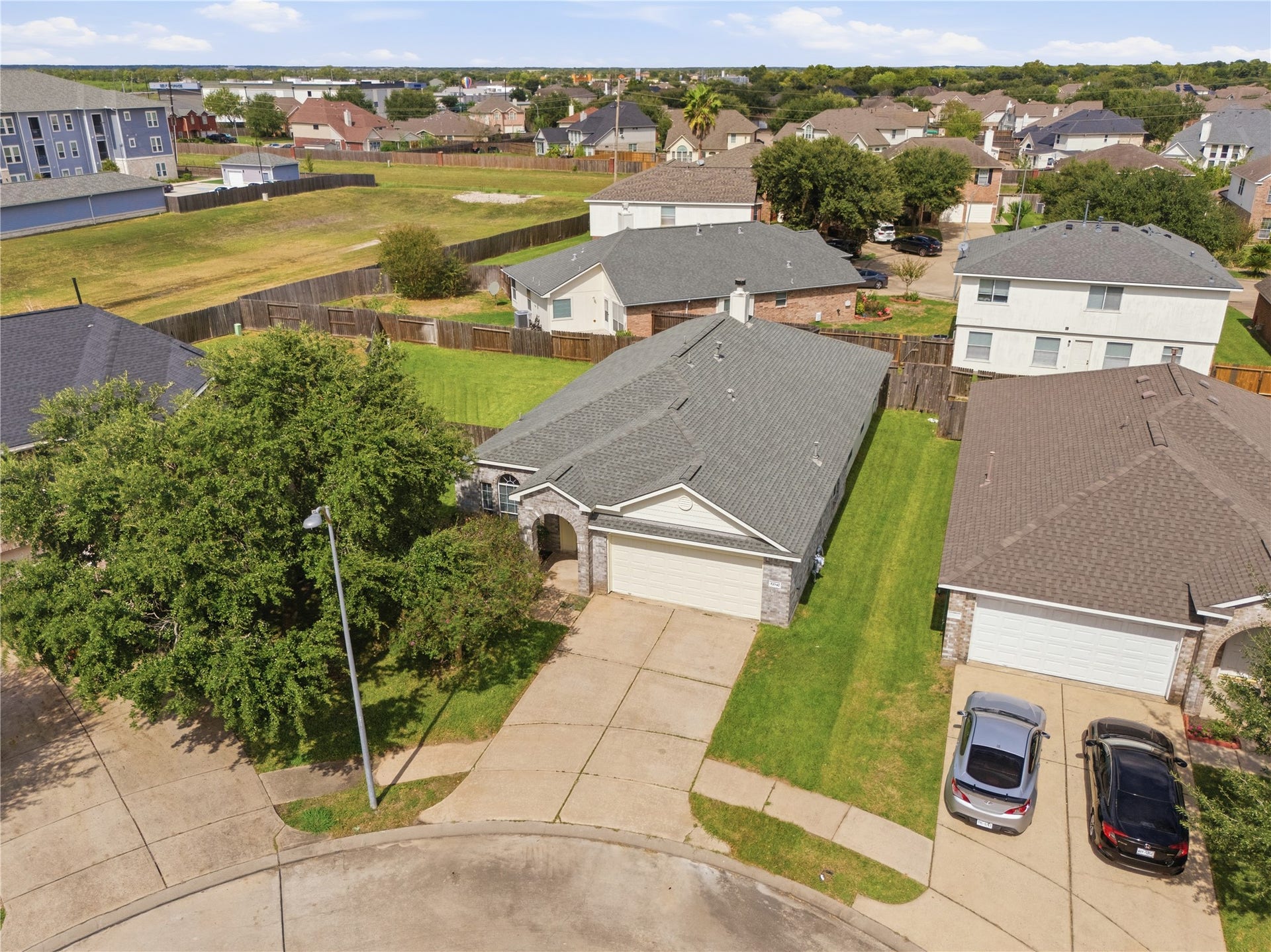 17042 Midnight Sun Lane, Richmond, TX 77407 Overhead view showcasing the home's beautiful curb appeal, mature shade tree, and well-maintained lot.