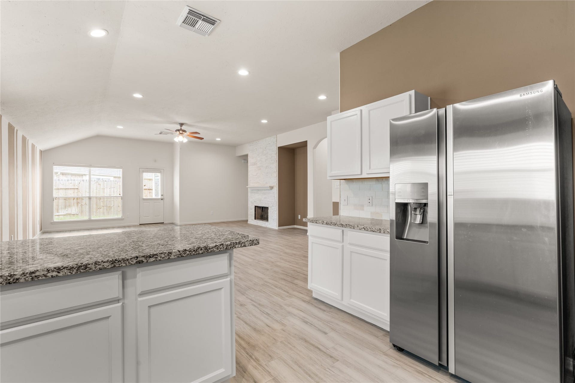 17042 Midnight Sun Lane, Richmond, TX 77407 Thoughtful design details shine through, with the fireplace stone coordinating seamlessly with the kitchen backsplash to create a cohesive and inviting living space.